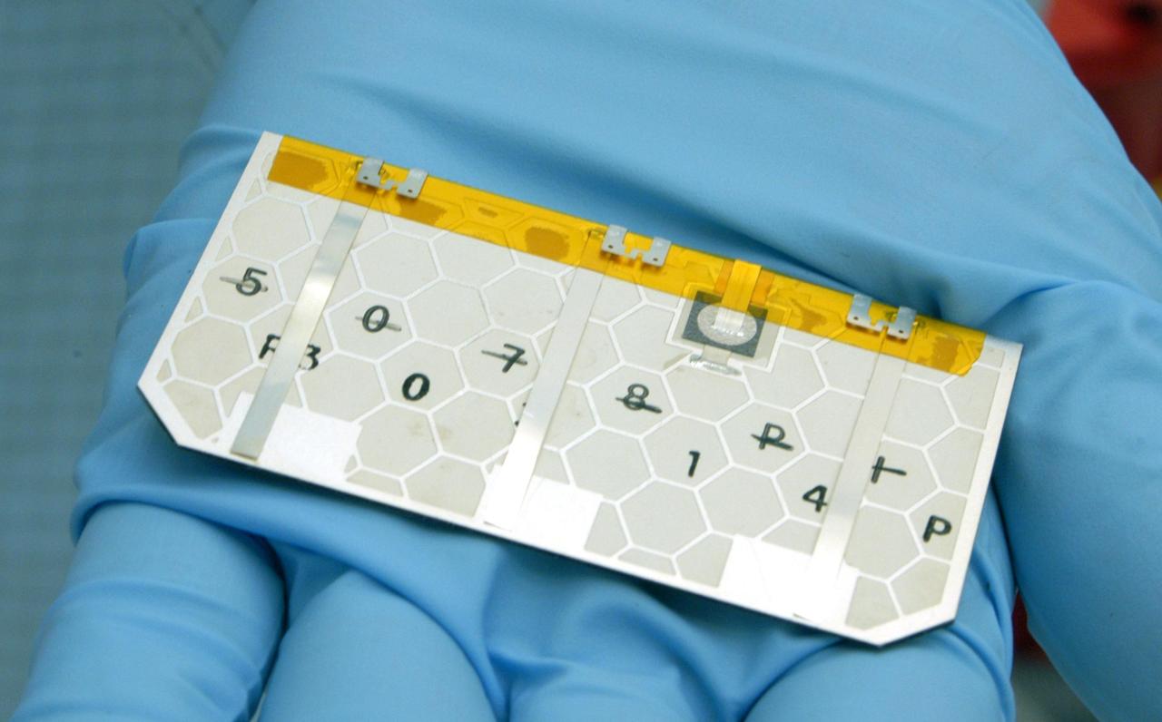 KENNEDY SPACE CENTER, FLA. -  A closeup of one of the solar cells that will be removed and replaced on the Swift spacecraft’s solar array.  Swift is a first-of-its-kind, multi-wavelength observatory dedicated to the study of gamma-ray burst (GRB) science. Its three instruments will work together to observe GRBs and afterglows in the gamma-ray, X-ray, ultraviolet and optical wavebands. The main mission objectives for Swift are to determine the origin of gamma-ray bursts, classify gamma-ray bursts and search for new types, determine how the blast wave evolves and interacts with the surroundings, use gamma-ray bursts to study the early universe and perform the first sensitive hard X-ray survey of the sky.  Swift is scheduled to launch Oct. 26 from Launch Pad 17-A, CCAFS, on a Boeing Delta 7320 rocket.