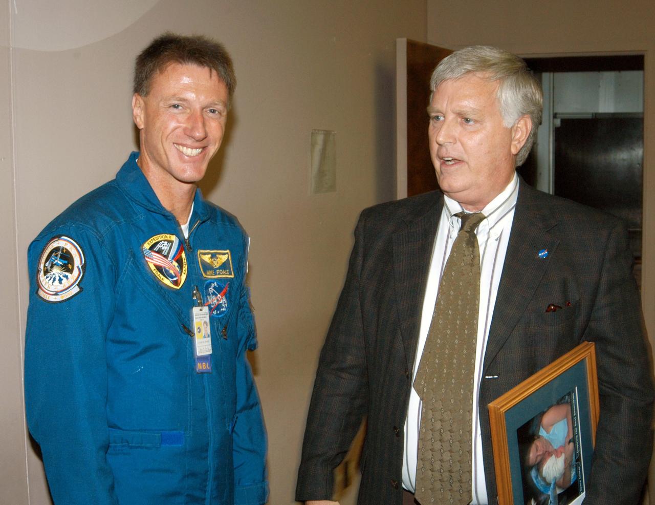KENNEDY SPACE CENTER, FLA. -  Astronaut Mike Foale, left, joins Center Director Jim Kennedy, right, in the Training Auditorium.  Foale spoke to the audience about his experiences aboard the International Space Station as commander of the Expedition 8 crew.  Foale and Flight Engineer Alexander Kaleri spent 194 days, 18 hours and 35 minutes in space, the second longest expedition to be completed aboard the Station. In February Foale and Kaleri conducted the first spacewalk ever performed from the complex by a two-person crew.   Foale has accumulated more time in space than any U.S. astronaut, amassing a total of 374 days, 11 hours and 19 minutes in space from his Expedition 8 mission, a 1997 flight to the Russian Mir Space Station, and four Space Shuttle missions.