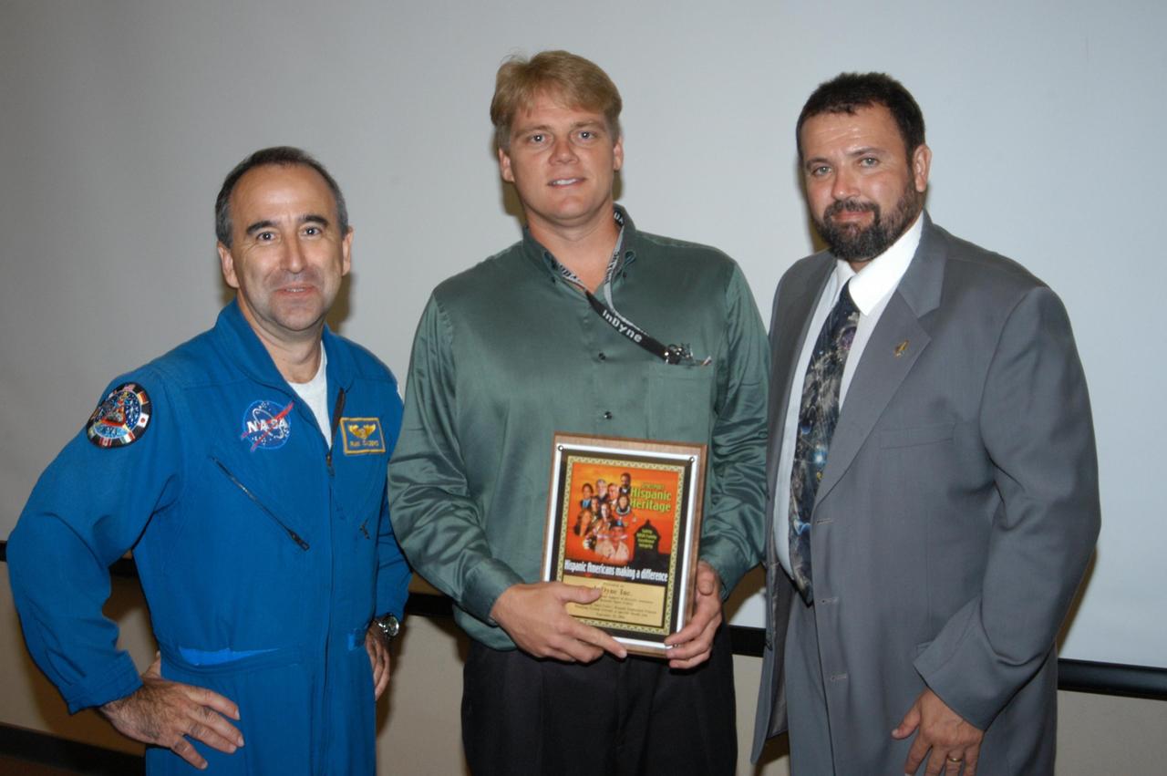 KENNEDY SPACE CENTER, FLA. -  Astronaut Fernando Caldeiro (left) and Joseph Tellado (right) present a memento of appreciation to Tom Neimeyer (with InDyne Corp.) at KSC’s  annual Hispanic American Heritage luncheon.  The theme was “Hispanic Americans Making a Difference.”  Tellado was co-chair of the event hosted by the Hispanic Employment Program Working Group. InDyne was one of the sponsors of the luncheon.  The annual event helps employees reflect on the extensive contributions Hispanics have made to KSC, NASA and the nation.