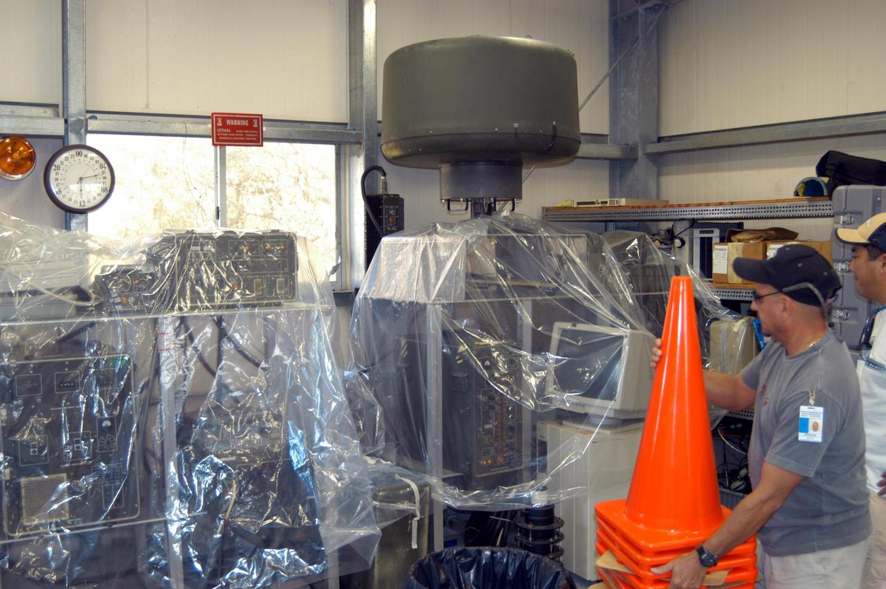 KENNEDY SPACE CENTER, FLA. - Workers place plastic sheets over racks of equipment in the Reusable Launch Vehicle Support Complex in preparation for the arrival of Hurricane Jeanne, expected to impact Central Florida Sunday. This is the fourth hurricane in 45 days to make landfall somewhere in the state.