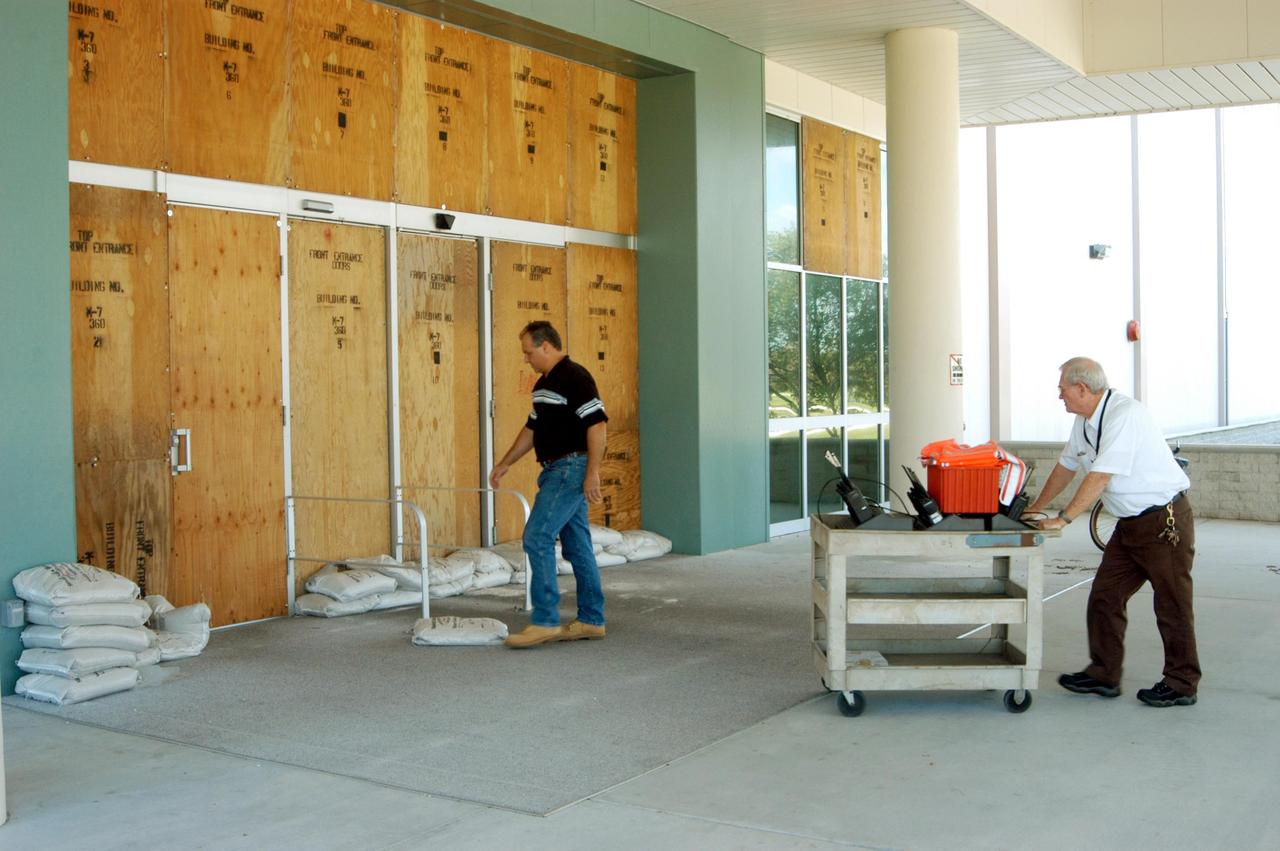 KENNEDY SPACE CENTER, FLA. - In preparation for Hurricane Jeanne, a worker places sandbags against the doors of the Space Station Processing Facility while another brings in emergency radios. The hurricane, expected to impact Central Florida Sunday, is the fourth hurricane in 45 days to make landfall somewhere in the state.