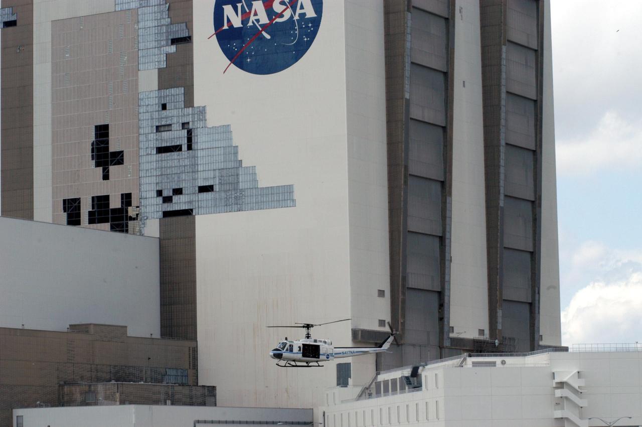 KENNEDY SPACE CENTER, FLA. - A helicopter moves past the Vehicle Assembly Building at KSC following the category 3 Hurricane Jeanne. The storm barreled through Central Florida Sept. 25-26 from the southeast. The VAB had lost 850 panels from the south wall during Hurricane Frances. Twenty-five additional panels were pulled off the east wall by the winds from Jeanne. This was the fourth hurricane in 6 weeks to batter the state.