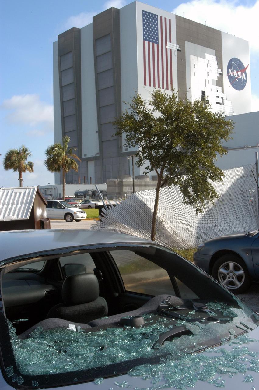 KENNEDY SPACE CENTER, FLA. - In a parking lot near the Vehicle Assembly Building (background), this car lost its rear window to the category 3 Hurricane Jeanne that barreled through Central Florida Sept. 25-26. Behind it is a fence mangled by the storm. Hurricane Jeanne was the fourth hurricane in 6 weeks to batter the state.