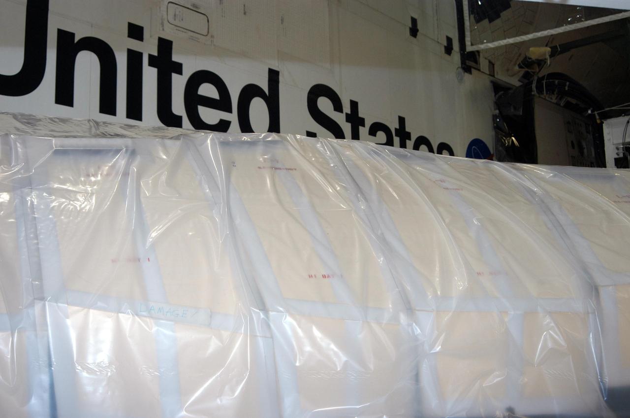 KENNEDY SPACE CENTER, FLA. - In the Orbiter Processing Facility, the wing of the orbiter Atlantis is covered in plastic, part of the preparation to protect the vehicles from possible damage by Hurricane Jeanne.  The storm ravaged Central Florida for 21 hours as it crossed the shoreline on the east coast Sept. 25-26.  Hurricane Jeanne was the fourth hurricane in 6 weeks to batter the state.