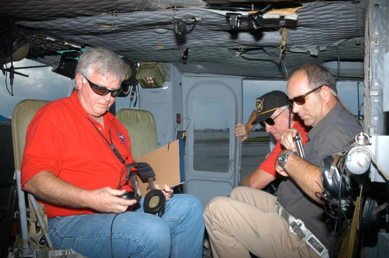 KENNEDY SPACE CENTER, FLA. - Center Director James Kennedy (left) is aboard a helicopter to observe damage from Hurricane Jeanne. A category 3 storm, Jeanne barreled through Central Florida Sept. 25-26, the fourth hurricane in 6 weeks to batter the state.