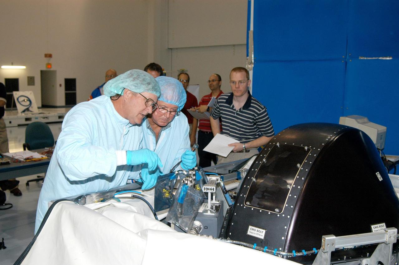 KENNEDY SPACE CENTER, FLA. - In the Space Station Processing Facility, workers conduct a post-delivery verification test on a Control Moment Gyro (CMG) that is scheduled to fly on mission STS-114.  The CMG will replace another on the International Space Station, which will require a spacewalk.