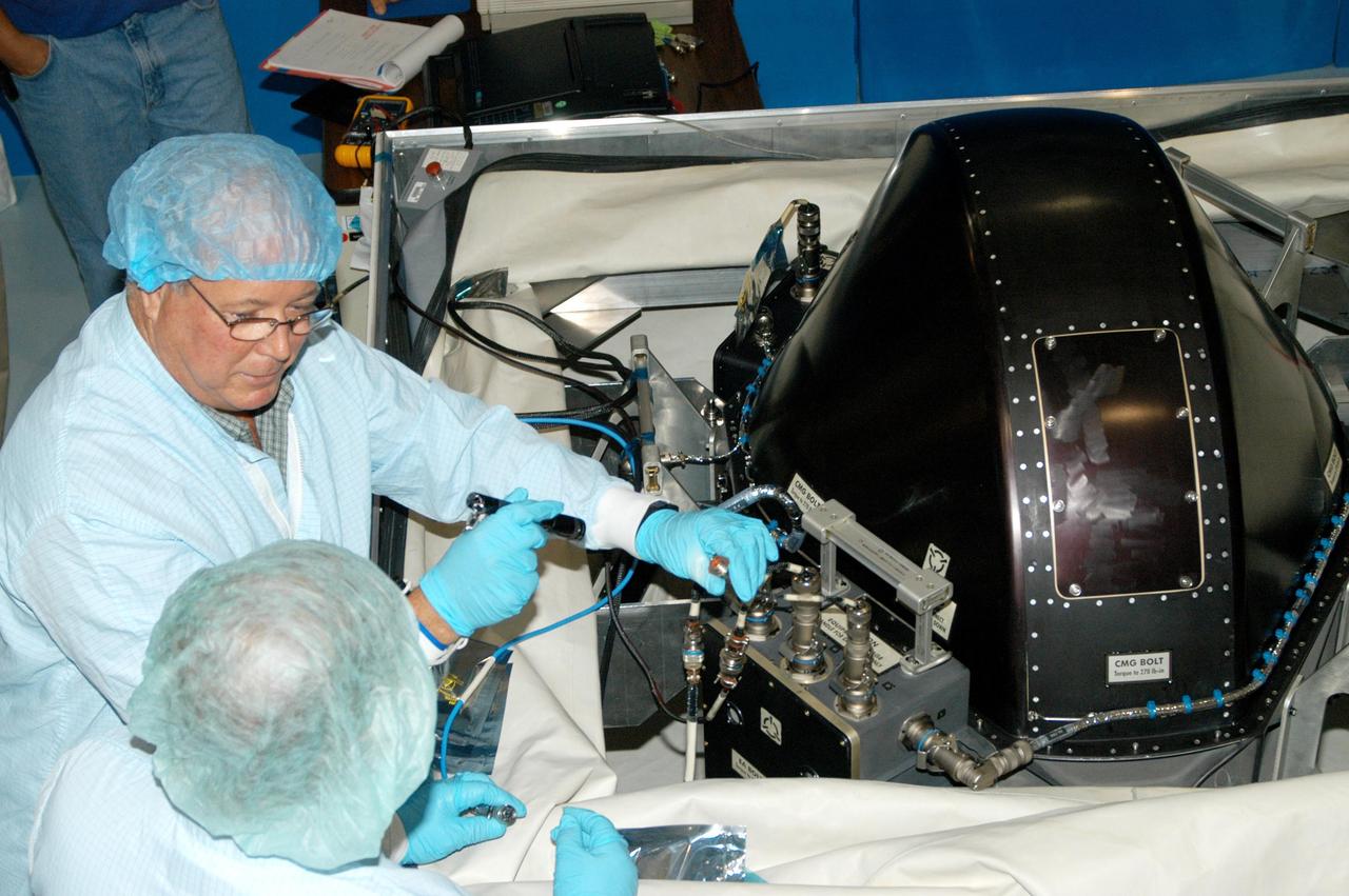 KENNEDY SPACE CENTER, FLA. - In the Space Station Processing Facility, workers conduct a post-delivery verification test on a Control Moment Gyro (CMG) that is scheduled to fly on mission STS-114.  The CMG will replace another on the International Space Station, which will require a spacewalk.