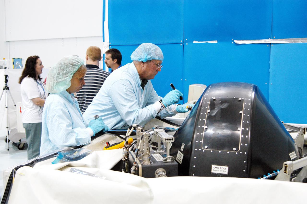 KENNEDY SPACE CENTER, FLA. - In the Space Station Processing Facility, workers conduct a post-delivery verification test on a Control Moment Gyro (CMG) that is scheduled to fly on mission STS-114.  The CMG will replace another on the International Space Station, which will require a spacewalk.