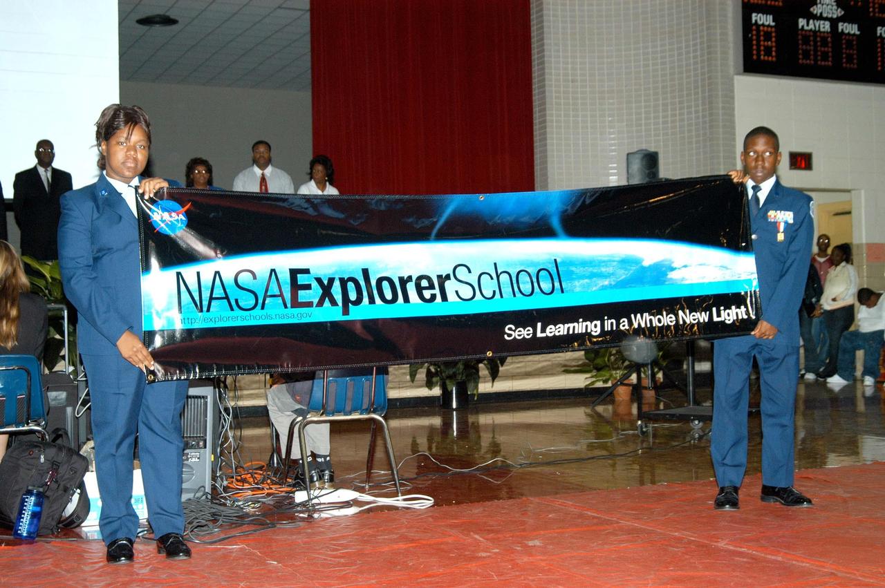 KENNEDY SPACE CENTER, FLA. - Two students at Ronald E. McNair High School in Atlanta proudly display the banner identifying McNair as a NASA Explorer School. The students enjoyed a presentation earlier by KSC Deputy Director Dr. Woodrow Whitlow Jr., astronaut Leland Melvin and Dr. Julian Earls, director of NASA Glenn Research Center. Whitlow talked with students about our destiny as explorers, NASA’s stepping stone approach to exploring Earth, the Moon, Mars and beyond, how space impacts our lives, and how people and machines rely on each other in space. Dr. Earls discussed the future and the vision for space, plus the NASA careers needed to meet the vision. Melvin talked about the importance of teamwork and what it takes for mission success.