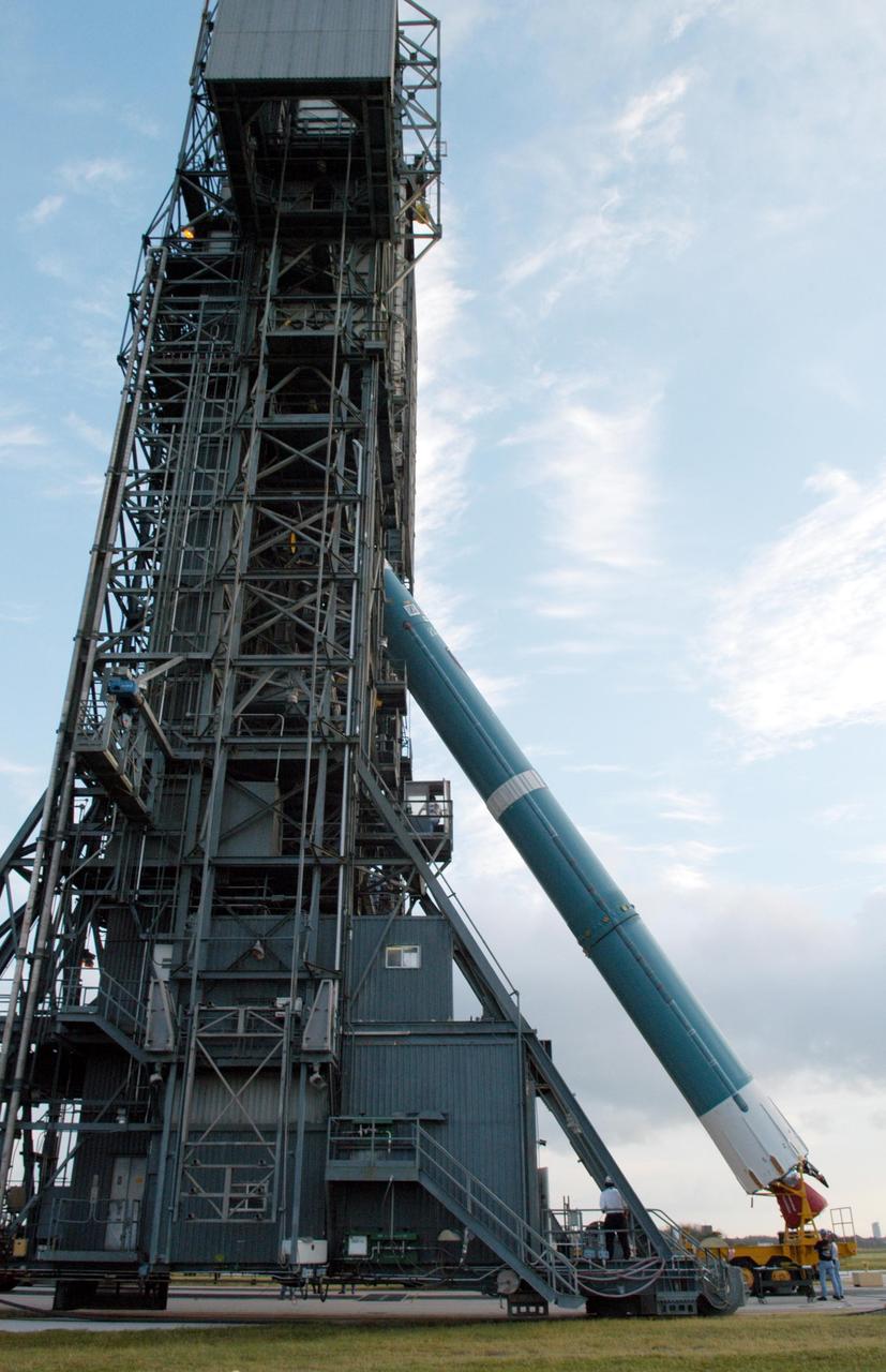 KENNEDY SPACE CENTER, FLA. -  On Launch Complex 17-A at Cape Canaveral Air Force Station, Fla., the first stage of a Boeing Delta II rocket is lifted toward the mobile service tower. To follow in the next week are attachment of the three strap-on solid rocket boosters, lifting of the payload fairing, and lifting of the second stage for mating with the first stage.   The rocket is the launch vehicle for the Swift spacecraft and its Gamma-Ray Burst Mission, now scheduled for liftoff no earlier than Nov. 2.  Swift is a medium-class Explorer mission managed by NASA’s Goddard Space Flight Center in Greenbelt, Md.  The observatory was built for NASA by Spectrum Astro, a division of General Dynamics.  KSC is responsible for Swift’s integration with the Boeing Delta II rocket and the countdown management on launch day.