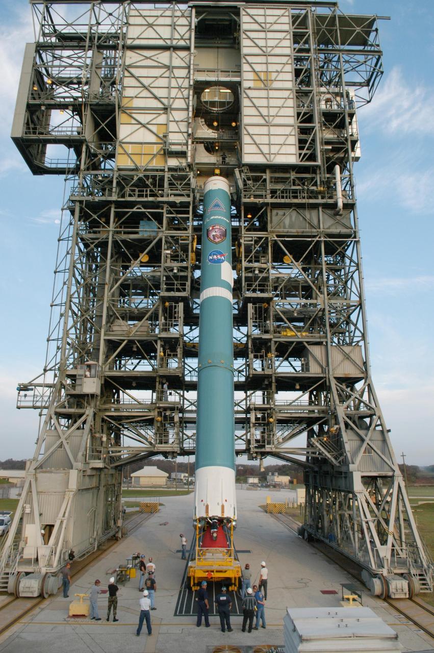 KENNEDY SPACE CENTER, FLA. -  On Launch Complex 17-A at Cape Canaveral Air Force Station, Fla., the first stage of a Boeing Delta II rocket is lifted toward the mobile service tower. To follow in the next week are attachment of the three strap-on solid rocket boosters, lifting of the payload fairing, and lifting of the second stage for mating with the first stage.   The rocket is the launch vehicle for the Swift spacecraft and its Gamma-Ray Burst Mission, now scheduled for liftoff no earlier than Nov. 2.  Swift is a medium-class Explorer mission managed by NASA’s Goddard Space Flight Center in Greenbelt, Md.  The observatory was built for NASA by Spectrum Astro, a division of General Dynamics.  KSC is responsible for Swift’s integration with the Boeing Delta II rocket and the countdown management on launch day.