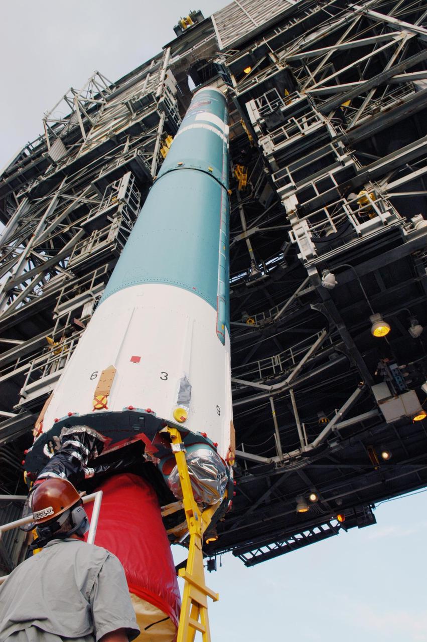 KENNEDY SPACE CENTER, FLA. -  On Launch Complex 17-A at Cape Canaveral Air Force Station, Fla., the first stage of a Boeing Delta II rocket is moved into place in the mobile service tower. To follow in the next week are attachment of the three strap-on solid rocket boosters, lifting of the payload fairing, and lifting of the second stage for mating with the first stage.   The rocket is the launch vehicle for the Swift spacecraft and its Gamma-Ray Burst Mission, now scheduled for liftoff no earlier than Nov. 2.  Swift is a medium-class Explorer mission managed by NASA’s Goddard Space Flight Center in Greenbelt, Md.  The observatory was built for NASA by Spectrum Astro, a division of General Dynamics.  KSC is responsible for Swift’s integration with the Boeing Delta II rocket and the countdown management on launch day.