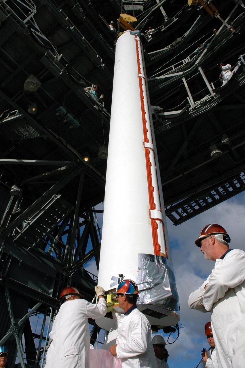 KENNEDY SPACE CENTER, FLA. - Technicians on Pad 17-A, Cape Canaveral Air Force Station, work on the bottom of the Solid Rocket Booster for the Swift-Delta launch before the SRB is raised into the mobile service tower. The SRB is one of three to be attached to the Boeing Delta rocket that is the launch vehicle for the Swift spacecraft and its Gamma-Ray Burst Mission. Swift is a medium-class Explorer mission managed by NASA’s Goddard Space Flight Center in Greenbelt, Md.
