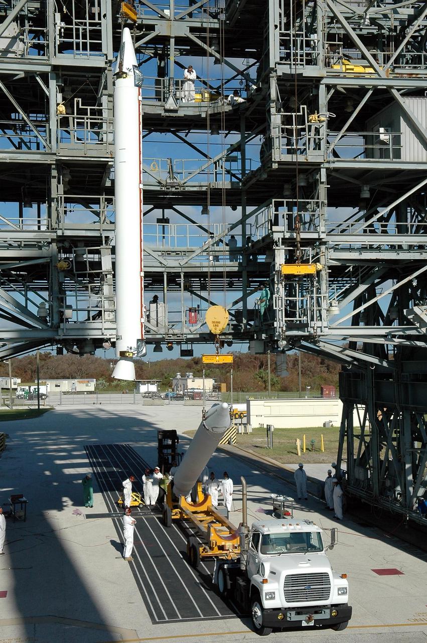 KENNEDY SPACE CENTER, FLA. - On Pad 17-A, Cape Canaveral Air Force Station, one Solid Rocket Booster is ready in the mobile service tower and a second is lifted from its transporter. In all, three SRBs will be attached to the Boeing Delta launch vehicle for the Swift spacecraft and its Gamma-Ray Burst Mission. Swift is a medium-class Explorer mission managed by NASA’s Goddard Space Flight Center in Greenbelt, Md.