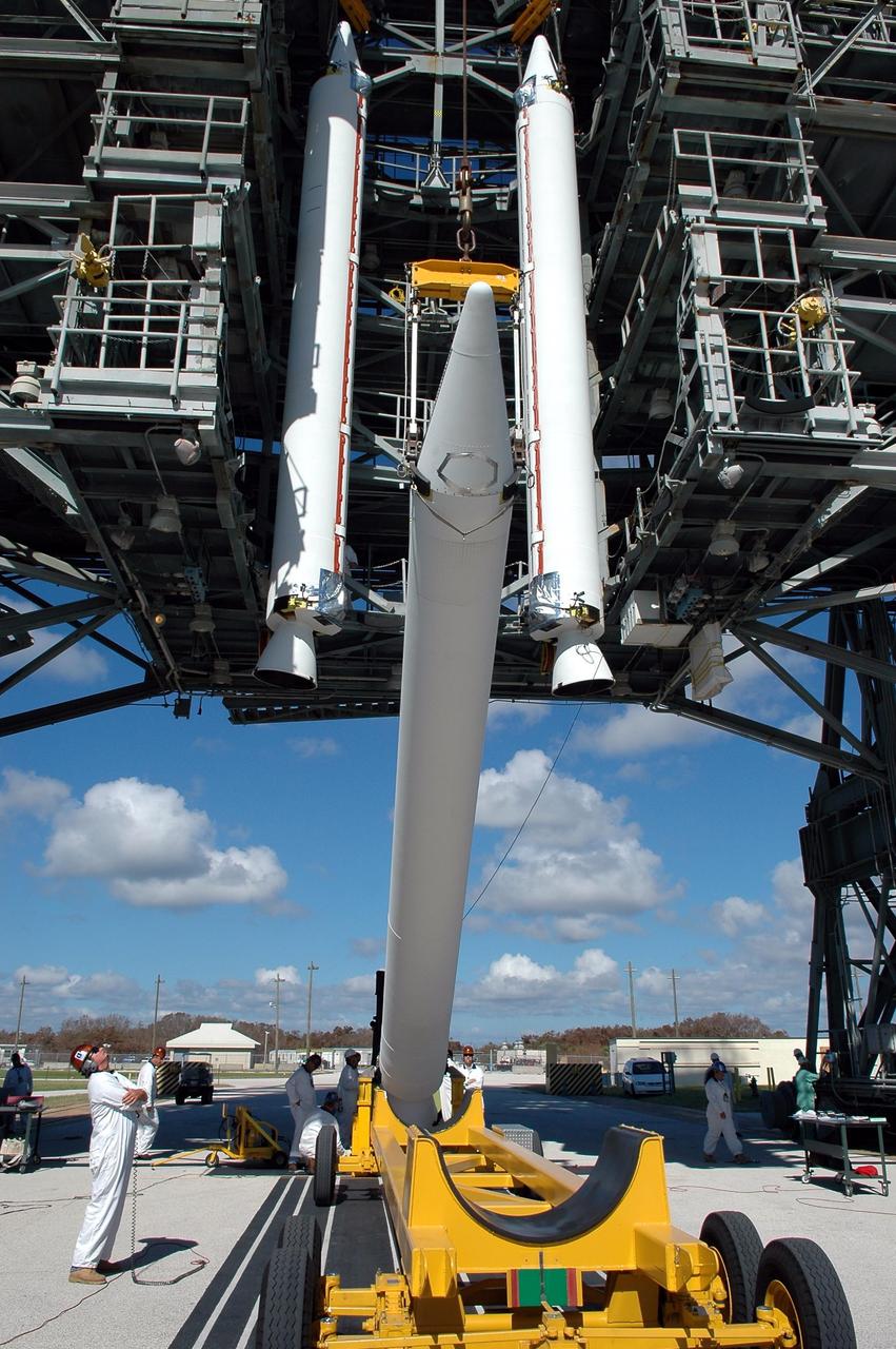 KENNEDY SPACE CENTER, FLA. - On Pad 17-A, Cape Canaveral Air Force Station, two Solid Rocket Boosters are ready in the mobile service tower and a third is lifted from its transporter. In all, three SRBs will be attached to the Boeing Delta launch vehicle for the Swift spacecraft and its Gamma-Ray Burst Mission. Swift is a medium-class Explorer mission managed by NASA’s Goddard Space Flight Center in Greenbelt, Md.