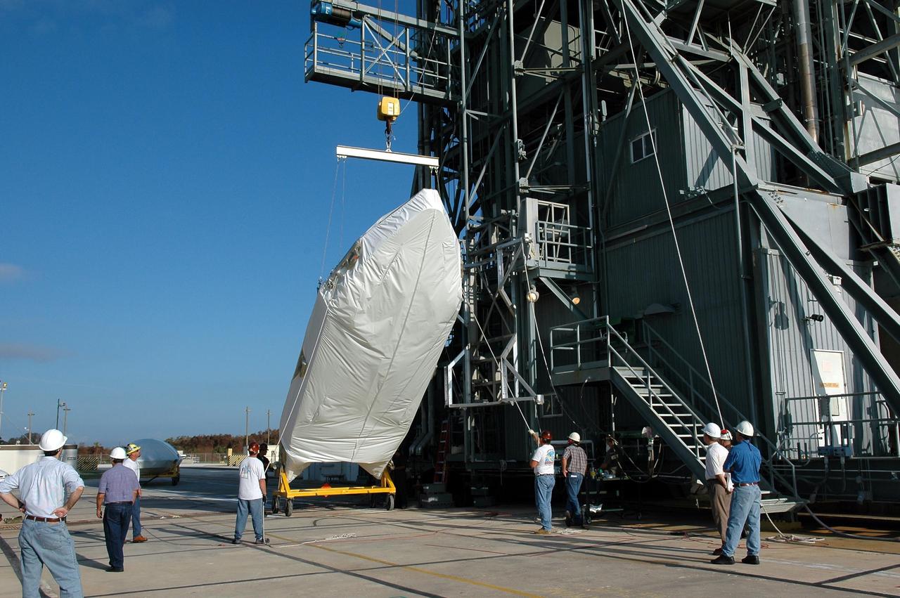 KENNEDY SPACE CENTER, FLA. - The fairing for the Swift-Delta launch is lifted off its transporter at pad 17-A, Cape Canaveral Air Force Station. The fairing is being lifted into mobile service tower to enclose the payload and protect it while on the launch pad and during ascent. The Boeing Delta rocket is the launch vehicle for the Swift spacecraft and its Gamma-Ray Burst Mission. Swift is a medium-class Explorer mission managed by NASA’s Goddard Space Flight Center in Greenbelt, Md.