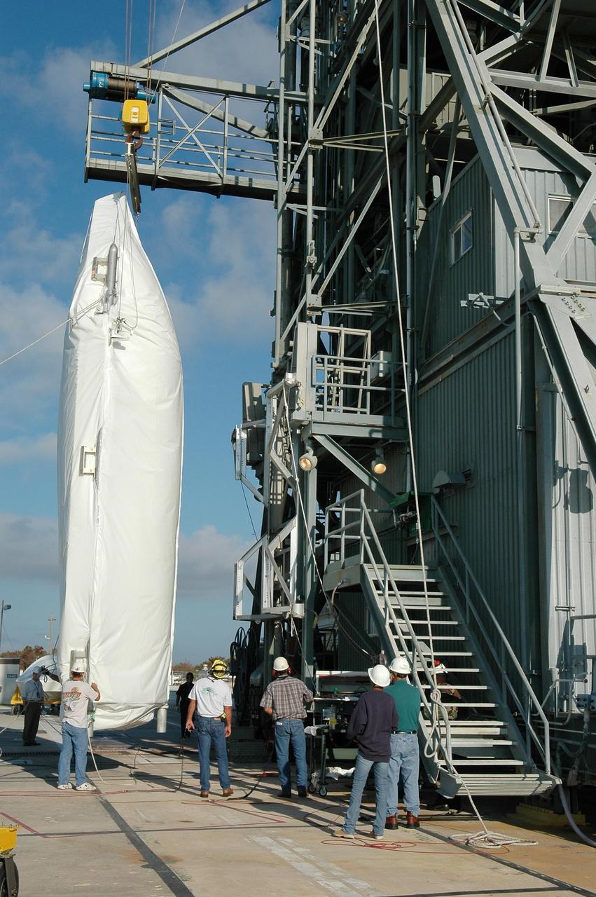 KENNEDY SPACE CENTER, FLA. - The fairing for the Swift-Delta launch is raised to a vertical position at pad 17-A, Cape Canaveral Air Force Station. The fairing is being lifted into mobile service tower to enclose the payload and protect it while on the launch pad and during ascent. The Boeing Delta rocket is the launch vehicle for the Swift spacecraft and its Gamma-Ray Burst Mission. Swift is a medium-class Explorer mission managed by NASA’s Goddard Space Flight Center in Greenbelt, Md.