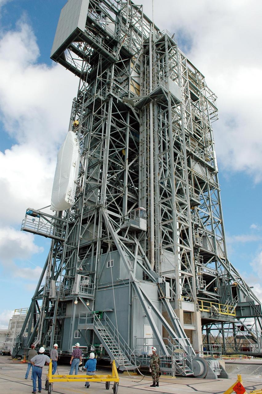 KENNEDY SPACE CENTER, FLA. - The fairing (on the left) for the Swift-Delta launch is lifted up the outside of the mobile service tower at pad 17-A, Cape Canaveral Air Force Station. The fairing will encapsulate the payload and protect it while on the launch pad and during ascent. The Boeing Delta rocket is the launch vehicle for the Swift spacecraft and its Gamma-Ray Burst Mission. Swift is a medium-class Explorer mission managed by NASA’s Goddard Space Flight Center in Greenbelt, Md.