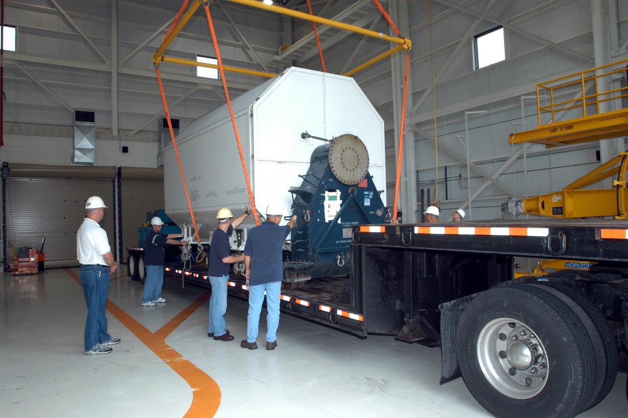 KENNEDY SPACE CENTER, FLA. -  Inside the KSC Engine Shop, Boeing-Rocketdyne technicians attach an overhead crane to the container enclosing the third Space Shuttle Main Engine for Discovery’s Return to Flight mission STS-114 arrives at the KSC Engine Shop aboard a trailer.  The engine is returning from NASA’s Stennis Space Center in Mississippi where it underwent a hot fire acceptance test. Typically, the engines are installed on an orbiter in the Orbiter Processing Facility approximately five months before launch.