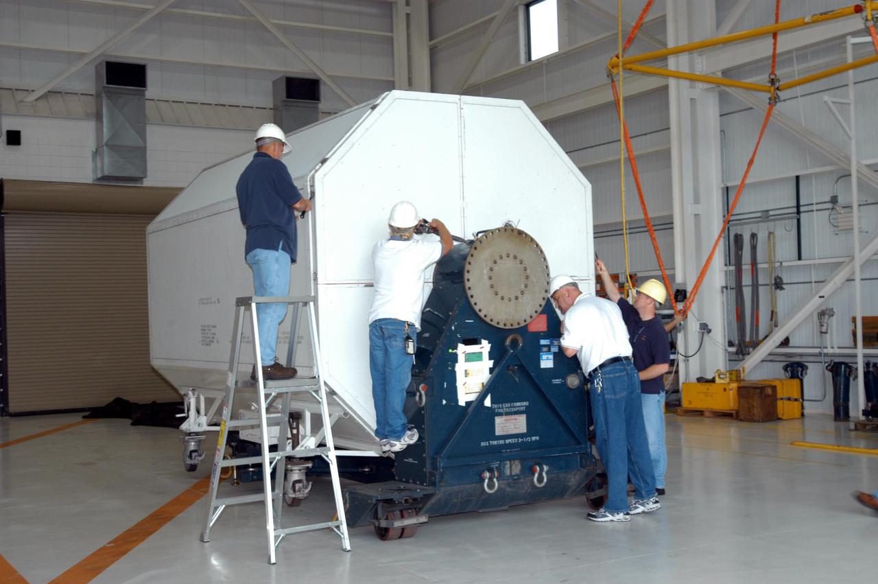 KENNEDY SPACE CENTER, FLA. -  Inside the KSC Engine Shop, Boeing-Rocketdyne technicians begin removing the end of the container enclosing the third Space Shuttle Main Engine for Discovery’s Return to Flight mission STS-114.  The engine is returning from NASA’s Stennis Space Center in Mississippi where it underwent a hot fire acceptance test. Typically, the engines are installed on an orbiter in the Orbiter Processing Facility approximately five months before launch.