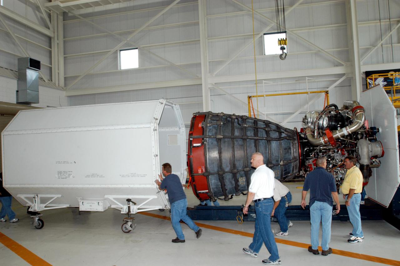 KENNEDY SPACE CENTER, FLA. -  Inside the KSC Engine Shop, Boeing-Rocketdyne technicians remove the container that enclosed the third Space Shuttle Main Engine for Discovery’s Return to Flight mission STS-114.  The engine is returning from NASA’s Stennis Space Center in Mississippi where it underwent a hot fire acceptance test. Typically, the engines are installed on an orbiter in the Orbiter Processing Facility approximately five months before launch.