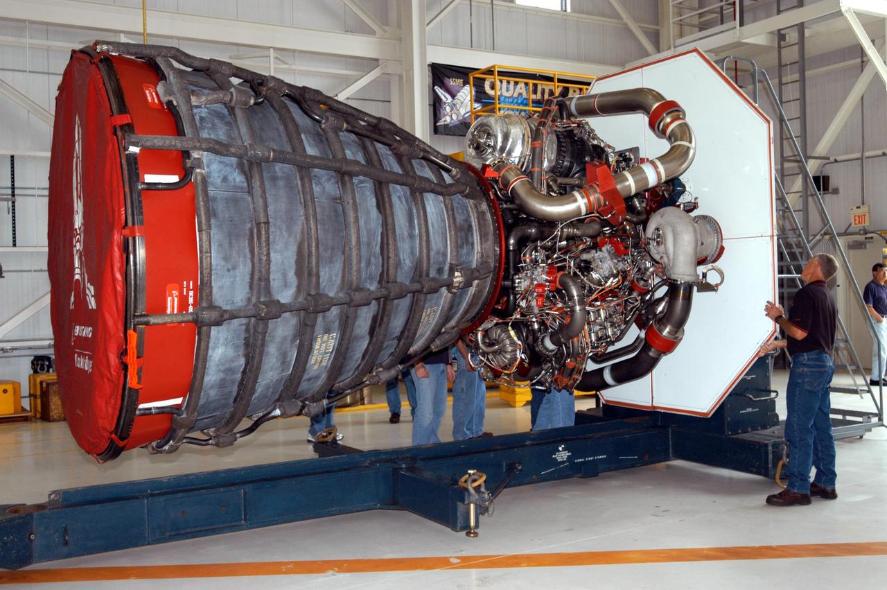 KENNEDY SPACE CENTER, FLA. -  Inside the KSC Engine Shop, Boeing-Rocketdyne technicians secure on a stand the third Space Shuttle Main Engine for Discovery’s Return to Flight mission STS-114.  The engine is returning from NASA’s Stennis Space Center in Mississippi where it underwent a hot fire acceptance test. Typically, the engines are installed on an orbiter in the Orbiter Processing Facility approximately five months before launch.