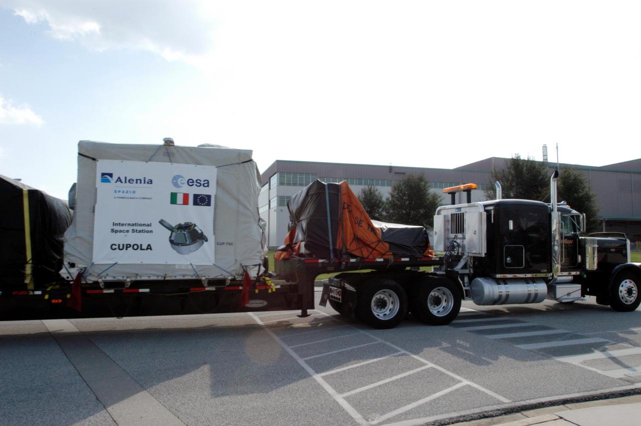 KENNEDY SPACE CENTER, FLA. - The Cupola, an element scheduled to be installed on the International Space Station in early 2009, arrives at KSC on the flatbed of a trailer.  It was shipped from Alenia Spazio in Turin, Italy, for the European Space Agency.  A dome-shaped module with seven windows, the Cupola will give astronauts a panoramic view for observing many operations on the outside of the orbiting complex.  The view out of the Cupola windows will enhance an arm operator's situational awareness, supplementing television camera views and graphics.  It will provide external observation capabilities during spacewalks, docking operations and hardware surveys and for Earth and celestial studies. The Cupola is the final element of the Space Station core.