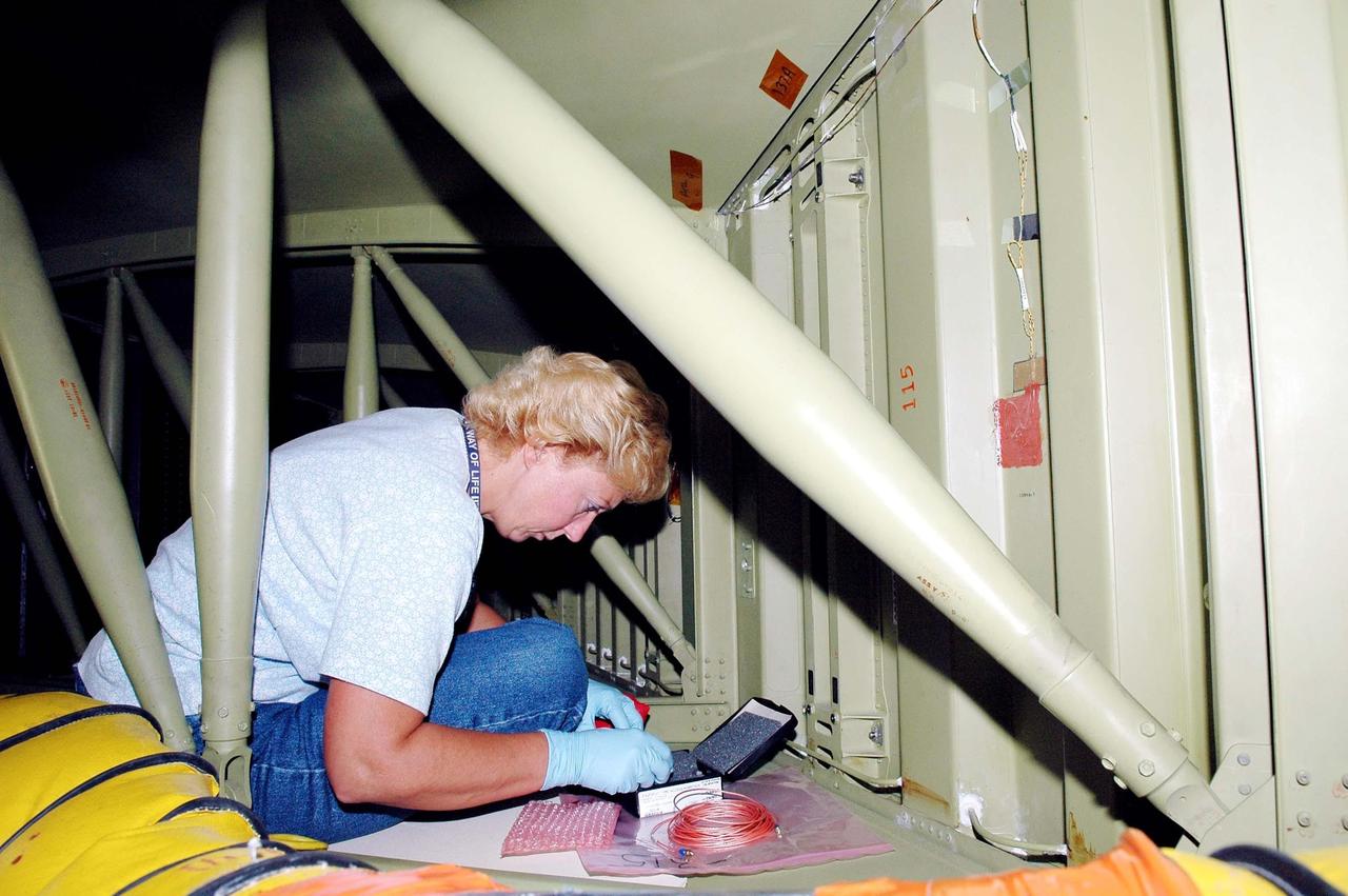 KENNEDY SPACE CENTER, FLA. - During an installation demonstration the Orbiter Processing Facility, United Space Alliance technician Lisa Campbell works with components of the sensor system being placed on the wing leading edge of orbiter Discovery. The sensors are part of the Wing Leading Edge Impact Detection System, a new safety measure added for all future Space Shuttle missions. The system also includes accelerometers that monitor the orbiter's wings for debris impacts during launch and while in orbit. There are 22 temperature sensors and 66 accelerometers on each wing. Sensor data will flow from the wing to the crew compartment, where it will be transmitted to Earth.