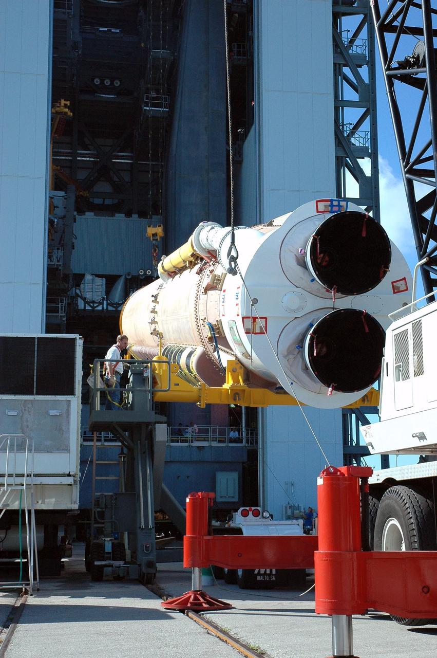 KENNEDY SPACE CENTER, FLA. - On Launch Complex 41 at Cape Canaveral Air Force Station, the first stage of an Atlas V rocket is lifted off the transporter. The rocket will be raised to vertical and then moved into the Vertical Integration Facility to begin preparations for launch. The Lockheed Martin Atlas V is the launch vehicle for the New Horizons spacecraft, which is designed to make the first reconnaissance of Pluto and Charon - a "double planet" and the last planet in our solar system to be visited by spacecraft. The mission will then visit one or more objects in the Kuiper Belt region beyond Neptune. New Horizons is scheduled to launch in January 2006, swing past Jupiter for a gravity boost and scientific studies in February or March 2007, and reach Pluto and its moon, Charon, in July 2015.
