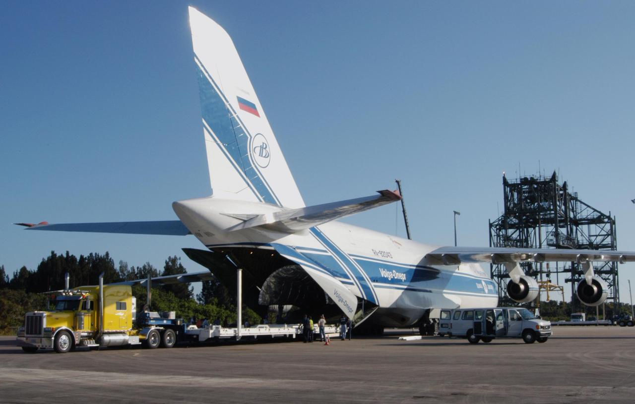 KENNEDY SPACE CENTER, FLA. - A Russian cargo plane sits on the Shuttle Landing Facility at NASA Kennedy Space Center with the Atlas V fairing for the New Horizons spacecraft inside. The two fairing halves will be removed, loaded onto trucks and transported to Astrotech Space Operations in Titusville. The fairing later will be placed around the New Horizons spacecraft in the Payload Hazardous Service Facility. A fairing protects a spacecraft during launch and flight through the atmosphere. Once in space, it is jettisoned. The Lockheed Martin Atlas V is the launch vehicle for the New Horizons spacecraft, which is designed to make the first reconnaissance of Pluto and Charon - a "double planet" and the last planet in our solar system to be visited by spacecraft. The mission will then visit one or more objects in the Kuiper Belt region beyond Neptune. New Horizons is scheduled to launch in January 2006, swing past Jupiter for a gravity boost and scientific studies in February or March 2007, and reach Pluto and its moon, Charon, in July 2015.