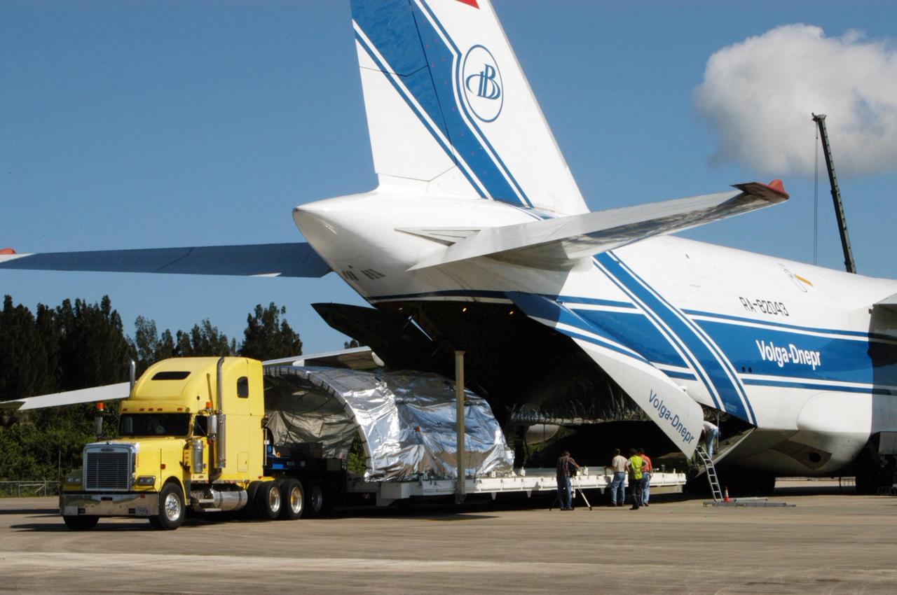 KENNEDY SPACE CENTER, FLA. - On the Shuttle Landing Facility at NASA Kennedy Space Center, one of the Atlas V fairing halves for the New Horizons spacecraft is offloaded from the Russian cargo plane. The fairing halves will be transported to Astrotech Space Operations in Titusville. The fairing later will be placed around the New Horizons spacecraft in the Payload Hazardous Service Facility. A fairing protects a spacecraft during launch and flight through the atmosphere. Once in space, it is jettisoned. The Lockheed Martin Atlas V is the launch vehicle for the New Horizons spacecraft, which is designed to make the first reconnaissance of Pluto and Charon - a "double planet" and the last planet in our solar system to be visited by spacecraft. The mission will then visit one or more objects in the Kuiper Belt region beyond Neptune. New Horizons is scheduled to launch in January 2006, swing past Jupiter for a gravity boost and scientific studies in February or March 2007, and reach Pluto and its moon, Charon, in July 2015.