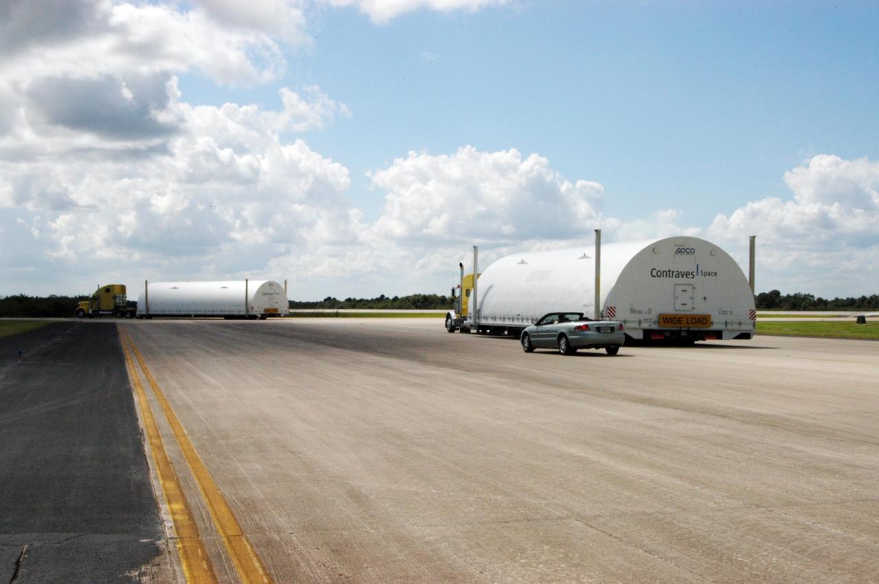 KENNEDY SPACE CENTER, FLA. - The Atlas V fairing halves for the New Horizons spacecraft are driven away from NASA Kennedy Space Center’s Shuttle Landing Facility. They are being transported to Astrotech Space Operations in Titusville. The fairing later will be placed around the New Horizons spacecraft in the Payload Hazardous Service Facility. The fairing later will be placed around the New Horizons spacecraft in the Payload Hazardous Service Facility. A fairing protects a spacecraft during launch and flight through the atmosphere. Once in space, it is jettisoned. The Lockheed Martin Atlas V is the launch vehicle for the New Horizons spacecraft, which is designed to make the first reconnaissance of Pluto and Charon - a "double planet" and the last planet in our solar system to be visited by spacecraft. The mission will then visit one or more objects in the Kuiper Belt region beyond Neptune. New Horizons is scheduled to launch in January 2006, swing past Jupiter for a gravity boost and scientific studies in February or March 2007, and reach Pluto and its moon, Charon, in July 2015.