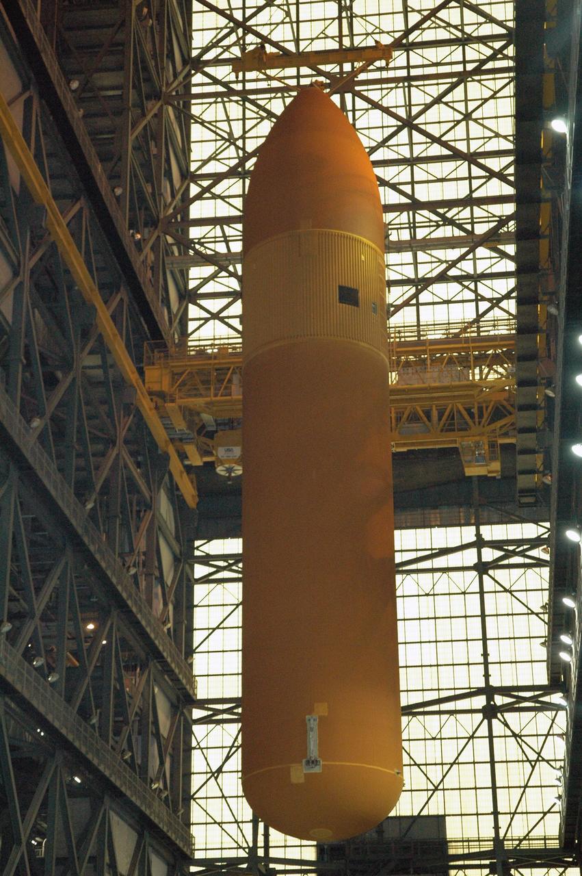 KENNEDY SPACE CENTER, FLA. -   This view shows the 154.2-foot-high external tank #120 as it is lowered in the transfer aisle of NASA Kennedy Space Center’s Vehicle Assembly Building.  It will be lowered to a horizontal position and placed on a transporter to wait for the return of the Pegasus barge from delivering tank #119 to Louisiana.  In a few weeks, tank #120 also will be returned to NASA’s Michoud Assembly Facility in Louisiana for routine testing and maintenance.   This tank is the first of the newly designed tanks that were delivered to Kennedy.  Previously stacked with Discovery, the tank has already gone through two tanking cycles during tanking tests but was replaced with tank #121 for Discovery’s return to flight mission STS-114