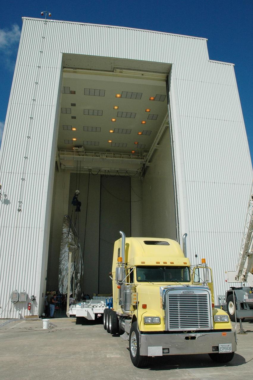 KENNEDY SPACE CENTER, FLA. -   Inside the Payload Hazardous Service Facility airlock, one of the fairing halves for the Lockheed Martin Atlas V rocket is suspended vertically.  The Atlas V is the launch vehicle for the New Horizons spacecraft.  The fairing will encapsulate the spacecraft to protect it during launch and flight through the atmosphere.  Once out of the atmosphere, the fairing is jettisoned. New Horizons is designed to make the first reconnaissance of Pluto and Charon - a "double planet" and the last planet in our solar system to be visited by spacecraft. The mission will then visit one or more objects in the Kuiper Belt region beyond Neptune. New Horizons is scheduled to launch in January 2006, swing past Jupiter for a gravity boost and scientific studies in February or March 2007, and reach Pluto and its moon, Charon, in July 2015.