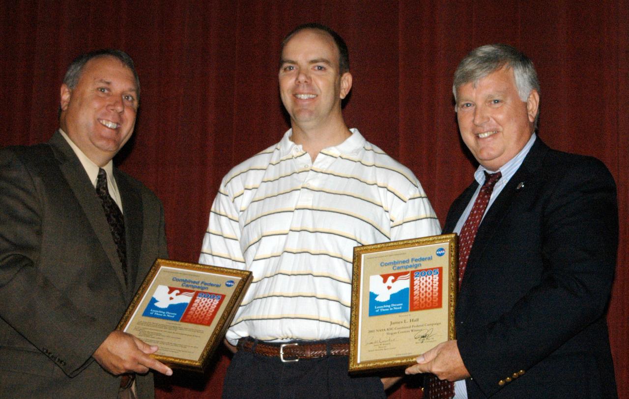 KENNEDY SPACE CENTER, FLA. -    In the NASA Kennedy Space Center Training Auditorium, President of United Way in Brevard Rob Rains (left) and Center Director Jim Kennedy (right) recognize James Hall (center) who submitted the winning theme for the center’s 2005 Combined Federal Campaign, “Launching Dreams of Those in Need.”  The occasion was the kickoff of the campaign at the center.  Guest speakers included Janet Bryant, executive director and CEO of the American Red Cross, Brevard County Chapter; Major Jack Owens, commanding officer of the Salvation Army, North/Central Brevard; and Rob Rains, president of United Way of Brevard. The campaign seeks voluntary donations from Federal civilian, postal and military workers during the campaign season to support eligible nonprofit organizations that provide health and human service benefits throughout the world.