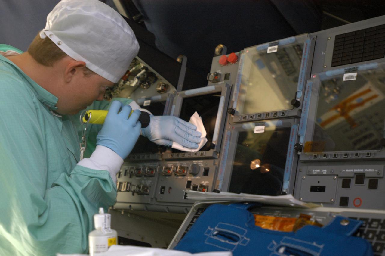KENNEDY SPACE CENTER, FLA. -   Carmen Prater, with United Space Alliance, cleans a screen on the flight deck of the orbiter Endeavour in bay 2 of the Orbiter Processing Facility.  She wears a “bunny suit,” clean room attire required for anyone coming in close proximity to the orbiter.  Endeavour is undergoing major modifications, which include inspecting more than 150 miles of wiring, bonding 1,000 thermal tiles, and installing the Multifunction Electronic Display Subsystem  - a state-of-the-art “glass cockpit.”  The full-color, flat-panel MEDS upgrade improves crew/orbiter interaction with easy-to-read, graphic portrayals of key flight indicators like attitude display and mach speed.