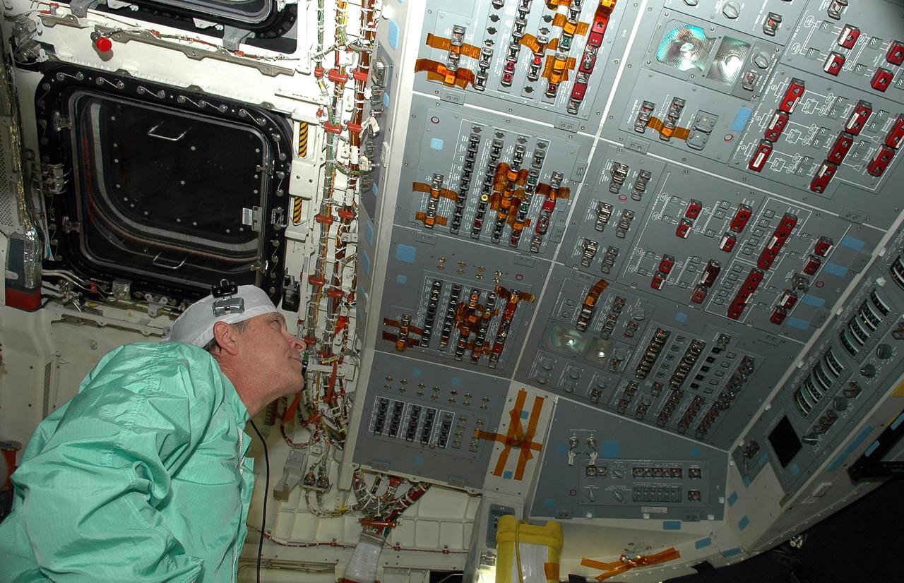 KENNEDY SPACE CENTER, FLA. -   In Orbiter Processing Facility bay 2, United Space Alliance technician Charles Bell monitors a display in Space Shuttle Endeavour's cockpit the first time the orbiter is powered up after nearly two years. Endeavour has been in its Orbiter Major Modification (OMM) period since December 2003. Engineers and technicians spent 900,000 hours performing 124 modifications to the vehicle. These included all recommended return to flight safety modifications, bonding more than 1,000 thermal protection system tiles and inspecting more than 150 miles of wiring throughout Endeavour. Eighty five of the modifications are completed, with work on the additional 39 modifications continuing throughout the next few months. Shuttle major modification periods are scheduled at regular intervals to enhance safety and performance, infuse new technology and allow for thorough inspections of the airframe and wiring of the vehicles. This was the second of these modification periods performed entirely at Kennedy Space Center. Endeavour's previous modification was completed in March 1997.
