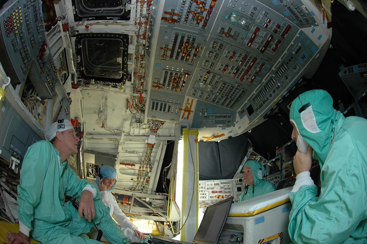 KENNEDY SPACE CENTER, FLA. - In Orbiter Processing Facility bay 2, United Space Alliance employees Charles Bell, Terri Halverstadt, Loralee Woodbury, and Rob Lewis monitor a display in Space Shuttle Endeavour's cockpit the first time the orbiter is powered up after nearly two years. Endeavour has been in its Orbiter Major Modification (OMM) period since December 2003. Engineers and technicians spent 900,000 hours performing 124 modifications to the vehicle. These included all recommended return to flight safety modifications, bonding more than 1,000 thermal protection system tiles and inspecting more than 150 miles of wiring throughout Endeavour. Eighty five of the modifications are completed, with work on the additional 39 modifications continuing throughout the next few months. Shuttle major modification periods are scheduled at regular intervals to enhance safety and performance, infuse new technology and allow for thorough inspections of the airframe and wiring of the vehicles. This was the second of these modification periods performed entirely at Kennedy Space Center. Endeavour's previous modification was completed in March 1997.