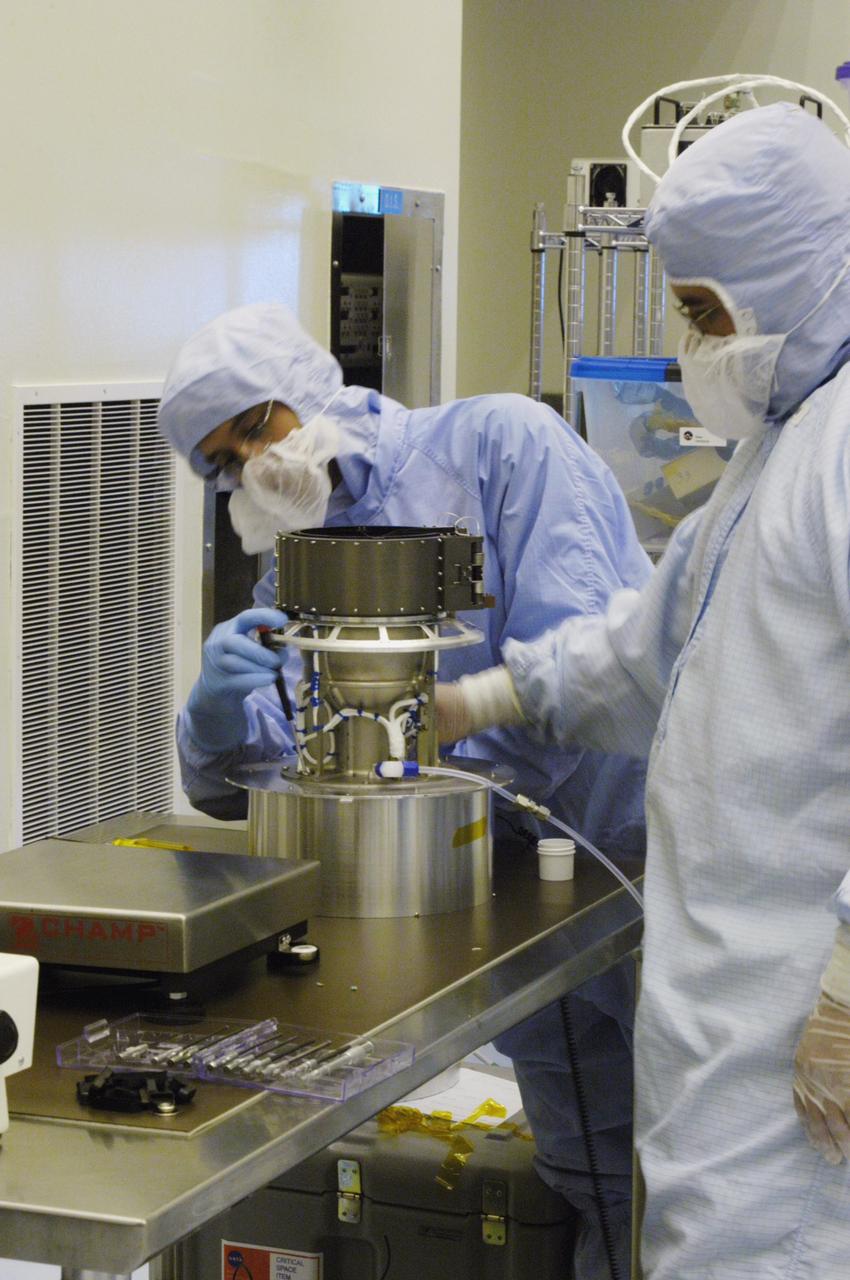 KENNEDY SPACE CENTER, FLA. - In the NASA Kennedy Space Center’s Payload Hazardous Servicing Facility, technicians work on the Solar Wind Around Pluto (SWAP) instrument that is part of the New Horizons spacecraft. New Horizons will make the first reconnaissance of Pluto and Charon - a "double planet" and the last planet in our solar system to be visited by spacecraft. The mission will then visit one or more objects in the Kuiper Belt region beyond Neptune. SWAP is a solar wind and plasma spectrometer that measures atmospheric “escape rate” and will observe Pluto’s interaction with the solar wind.  New Horizons is scheduled to launch in January 2006, swing past Jupiter for a gravity boost and scientific studies in February or March 2007, and reach Pluto and its moon, Charon, in July 2015.