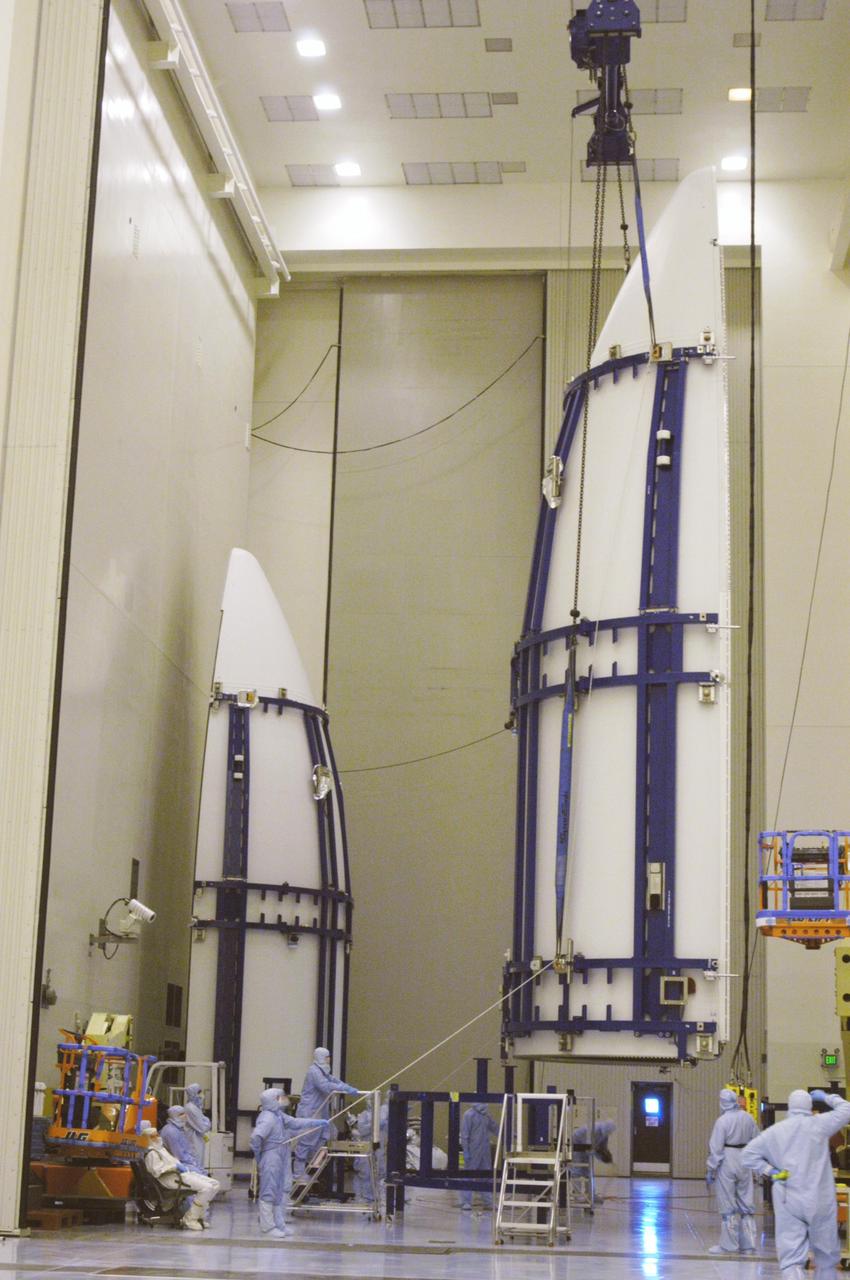 KENNEDY SPACE CENTER, FLA. - In the NASA Kennedy Space Center’s Payload Hazardous Servicing Facility, one part of the Lockheed Martin Atlas V rocket fairing to be placed around the New Horizons spacecraft is moved after being lifted from a stand. The fairing encapsulates the spacecraft to protect it during launch and flight through the atmosphere. Once out of the atmosphere, the fairing is jettisoned. New Horizons will make the first reconnaissance of Pluto and Charon - a "double planet" and the last planet in our solar system to be visited by spacecraft. The mission will then visit one or more objects in the Kuiper Belt region beyond Neptune. SWAP is a solar wind and plasma spectrometer that measures atmospheric “escape rate” and will observe Pluto’s interaction with the solar wind. New Horizons is scheduled to launch in January 2006, swing past Jupiter for a gravity boost and scientific studies in February or March 2007, and reach Pluto and its moon, Charon, in July 2015.