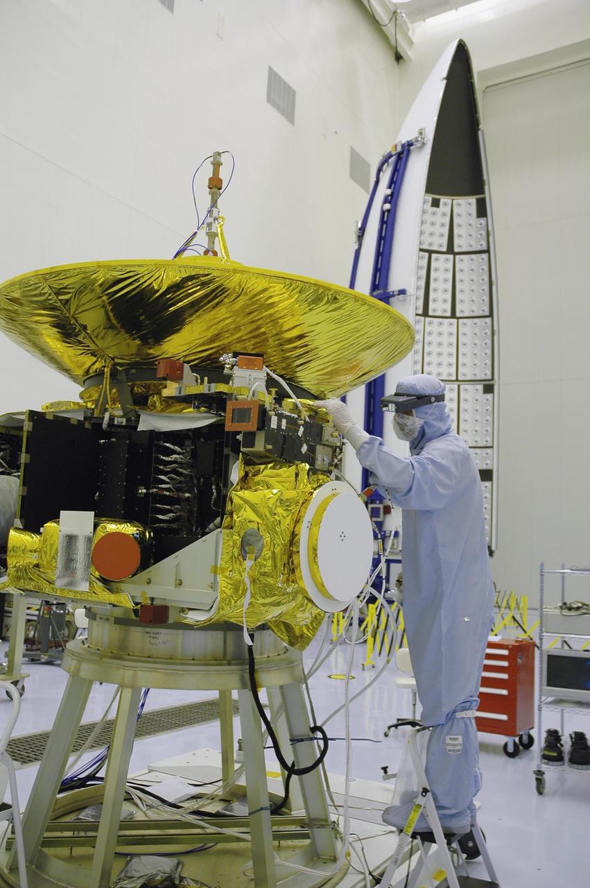 KENNEDY SPACE CENTER, FLA. - At NASA Kennedy Space Center’s Payload Hazardous Servicing Facility, technicians from the Applied Physics Laboratory work on a panel they are installing on the New Horizons spacecraft. A series of interconnecting panels will enclose the spacecraft beneath the antenna to maintain safe operating temperatures in space. New Horizons will make the first reconnaissance of Pluto and its moon, Charon - a "double planet" and the last planet in our solar system to be visited by spacecraft. As it approaches Pluto, the spacecraft will look for ultraviolet emission from Pluto's atmosphere and make the best global maps of Pluto and Charon in green, blue, red and a special wavelength that is sensitive to methane frost on the surface. It will also take spectral maps in the near infrared, telling the science team about Pluto's and Charon's surface compositions and locations and temperatures of these materials. When the spacecraft is closest to Pluto or its moon, it will take close-up pictures in both visible and near-infrared wavelengths. The mission will then visit one or more objects in the Kuiper Belt region beyond Neptune. New Horizons is scheduled to launch in January 2006, swing past Jupiter for a gravity boost and scientific studies in February or March 2007, and reach Pluto and Charon in July 2015.