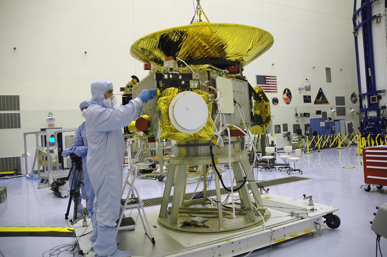 KENNEDY SPACE CENTER, FLA. - At NASA Kennedy Space Center’s Payload Hazardous Servicing Facility, technicians work on a panel they are installing on the New Horizons spacecraft. A series of interconnecting panels will enclose the spacecraft beneath the antenna to maintain safe operating temperatures in space. New Horizons will make the first reconnaissance of Pluto and its moon, Charon - a "double planet" and the last planet in our solar system to be visited by spacecraft. As it approaches Pluto, the spacecraft will look for ultraviolet emission from Pluto's atmosphere and make the best global maps of Pluto and Charon in green, blue, red and a special wavelength that is sensitive to methane frost on the surface. It will also take spectral maps in the near infrared, telling the science team about Pluto's and Charon's surface compositions and locations and temperatures of these materials. When the spacecraft is closest to Pluto or its moon, it will take close-up pictures in both visible and near-infrared wavelengths. The mission will then visit one or more objects in the Kuiper Belt region beyond Neptune. New Horizons is scheduled to launch in January 2006, swing past Jupiter for a gravity boost and scientific studies in February or March 2007, and reach Pluto and Charon in July 2015.