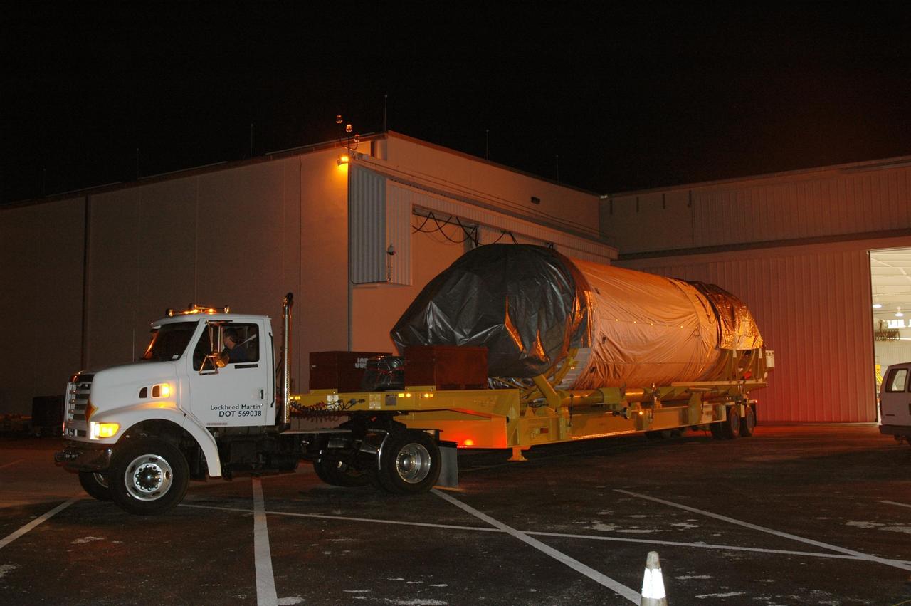 KENNEDY SPACE CENTER, FLA. - The Lockheed Martin Atlas V Centaur stage leaves the Astrotech Space Operations Center in Titusville, Fla., for the short journey to Launch Complex 41 at Cape Canaveral Air Force Station. The Centaur is the second stage of the launch vehicle for the New Horizons spacecraft. New Horizons will make the first reconnaissance of Pluto and its moon, Charon - a "double planet" and the last planet in our solar system to be visited by spacecraft. As it approaches Pluto, the spacecraft will look for ultraviolet emission from Pluto's atmosphere and make the best global maps of Pluto and Charon in green, blue, red and a special wavelength that is sensitive to methane frost on the surface. It will also take spectral maps in the near infrared, telling the science team about Pluto's and Charon's surface compositions and locations and temperatures of these materials. When the spacecraft is closest to Pluto or its moon, it will take close-up pictures in both visible and near-infrared wavelengths. The mission will then visit one or more objects in the Kuiper Belt region beyond Neptune. New Horizons is scheduled to launch in January 2006, swing past Jupiter for a gravity boost and scientific studies in February or March 2007, and reach Pluto and Charon in July 2015.