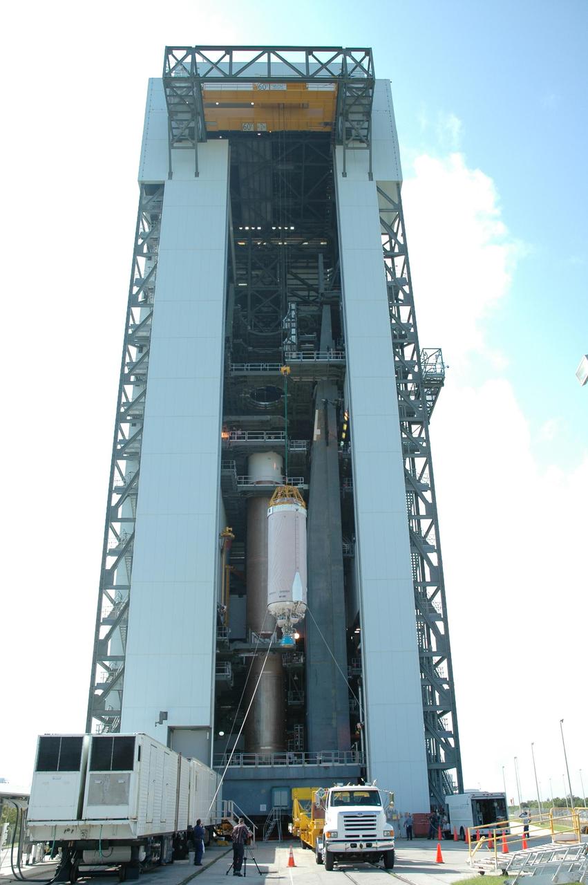 KENNEDY SPACE CENTER, FLA. - On Launch Complex 41 at Cape Canaveral Air Force Station in Florida, the Lockheed Martin Atlas V Centaur stage is lifted up the mobile service tower where it will be mated with the waiting first stage, seen behind it at left. New Horizons will make the first reconnaissance of Pluto and its moon, Charon - a "double planet" and the last planet in our solar system to be visited by spacecraft. As it approaches Pluto, the spacecraft will look for ultraviolet emission from Pluto's atmosphere and make the best global maps of Pluto and Charon in green, blue, red and a special wavelength that is sensitive to methane frost on the surface. It will also take spectral maps in the near infrared, telling the science team about Pluto's and Charon's surface compositions and locations and temperatures of these materials. When the spacecraft is closest to Pluto or its moon, it will take close-up pictures in both visible and near-infrared wavelengths. The mission will then visit one or more objects in the Kuiper Belt region beyond Neptune. New Horizons is scheduled to launch in January 2006, swing past Jupiter for a gravity boost and scientific studies in February or March 2007, and reach Pluto and Charon in July 2015.