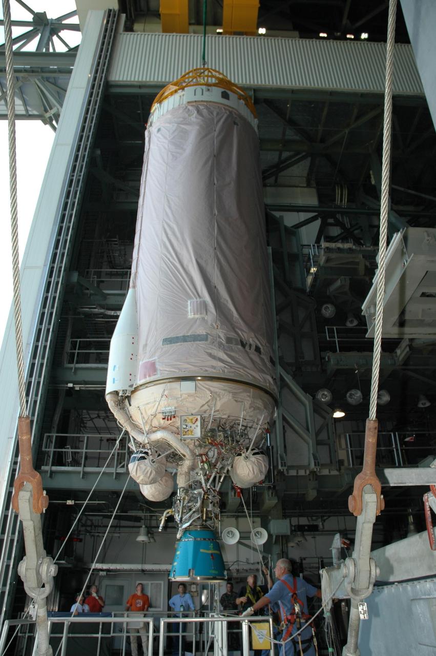 KENNEDY SPACE CENTER, FLA. - Inside the mobile service tower on Launch Complex 41 at Cape Canaveral Air Force Station in Florida, the Lockheed Martin Atlas V Centaur stage is moved into place over the waiting first stage below it. The launch vehicle for the New Horizon spacecraft, the Atlas V first and second stages will be mated. New Horizons will make the first reconnaissance of Pluto and its moon, Charon - a "double planet" and the last planet in our solar system to be visited by spacecraft. As it approaches Pluto, the spacecraft will look for ultraviolet emission from Pluto's atmosphere and make the best global maps of Pluto and Charon in green, blue, red and a special wavelength that is sensitive to methane frost on the surface. It will also take spectral maps in the near infrared, telling the science team about Pluto's and Charon's surface compositions and locations and temperatures of these materials. When the spacecraft is closest to Pluto or its moon, it will take close-up pictures in both visible and near-infrared wavelengths. The mission will then visit one or more objects in the Kuiper Belt region beyond Neptune. New Horizons is scheduled to launch in January 2006, swing past Jupiter for a gravity boost and scientific studies in February or March 2007, and reach Pluto and Charon in July 2015.