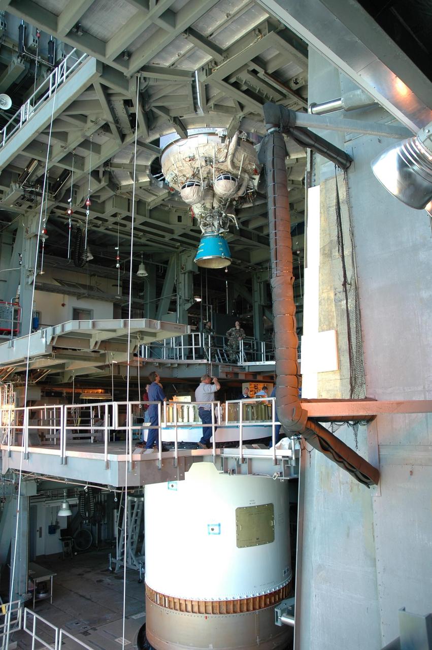 KENNEDY SPACE CENTER, FLA. - Inside the mobile service tower on Launch Complex 41 at Cape Canaveral Air Force Station in Florida, workers wait for the Lockheed Martin Atlas V Centaur stage (above) to be lowered to the first stage for installation. The Atlas V is the launch vehicle for the New Horizons spacecraft. New Horizons will make the first reconnaissance of Pluto and its moon, Charon - a "double planet" and the last planet in our solar system to be visited by spacecraft. As it approaches Pluto, the spacecraft will look for ultraviolet emission from Pluto's atmosphere and make the best global maps of Pluto and Charon in green, blue, red and a special wavelength that is sensitive to methane frost on the surface. It will also take spectral maps in the near infrared, telling the science team about Pluto's and Charon's surface compositions and locations and temperatures of these materials. When the spacecraft is closest to Pluto or its moon, it will take close-up pictures in both visible and near-infrared wavelengths. The mission will then visit one or more objects in the Kuiper Belt region beyond Neptune. New Horizons is scheduled to launch in January 2006, swing past Jupiter for a gravity boost and scientific studies in February or March 2007, and reach Pluto and Charon in July 2015.