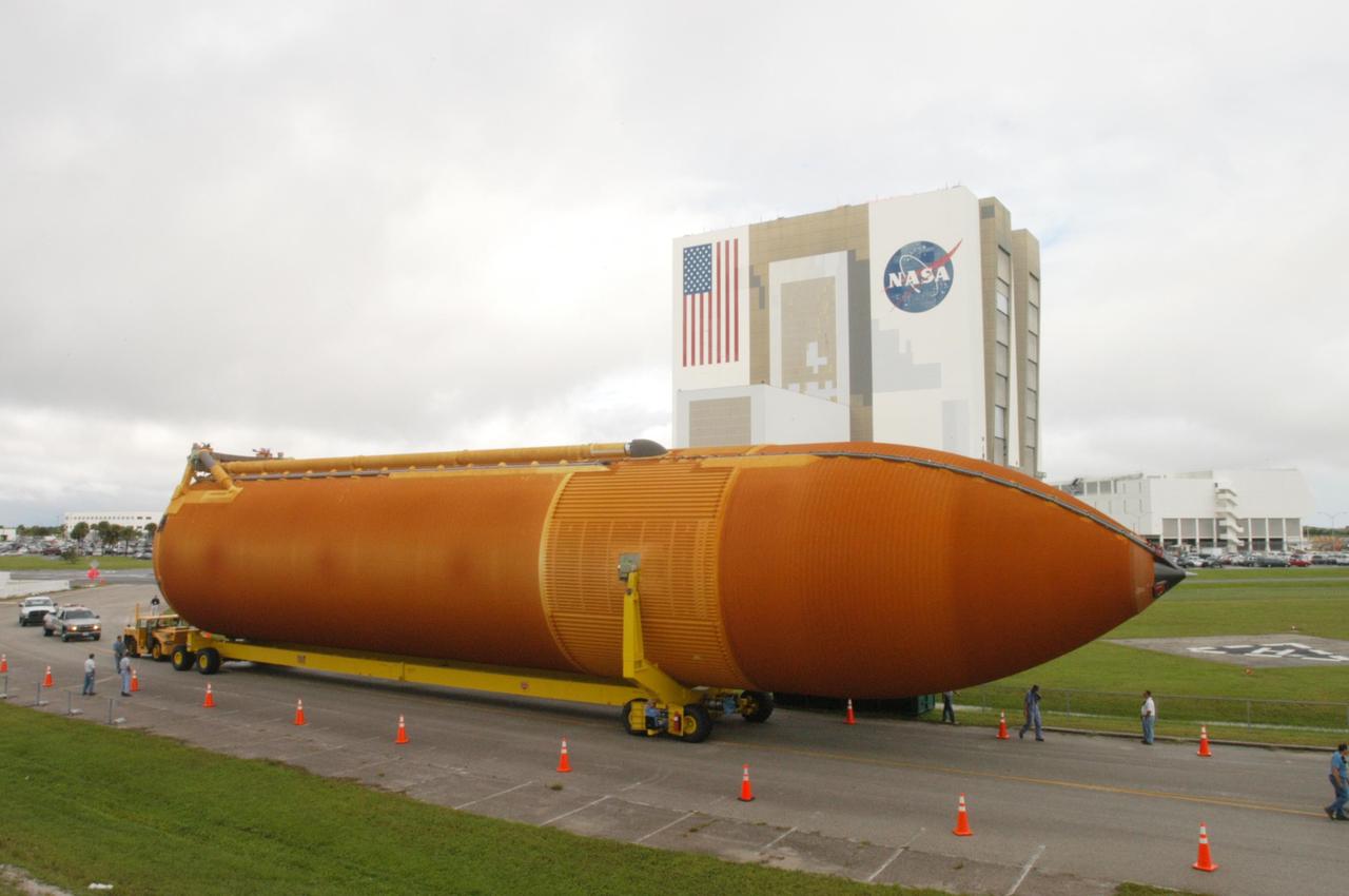 KENNEDY SPACE CENTER, FLA. -  External tank 120 is moved from NASA Kennedy Space Center’s Vehicle Assembly Building (in the background) to the Turn Basin and the waiting barge Pegasus.  The tank will be loaded onto the barge for transport to NASA’s Michoud Assembly Facility in Louisiana for additional modifications.  This tank is the first of the newly designed tanks that were delivered to Kennedy.  Previously, the tank was stacked with Discovery and, more recently, Atlantis.  The tank has already gone through two tanking cycles during tanking tests but was replaced with tank #121 for Discovery’s return to flight mission STS-114.
