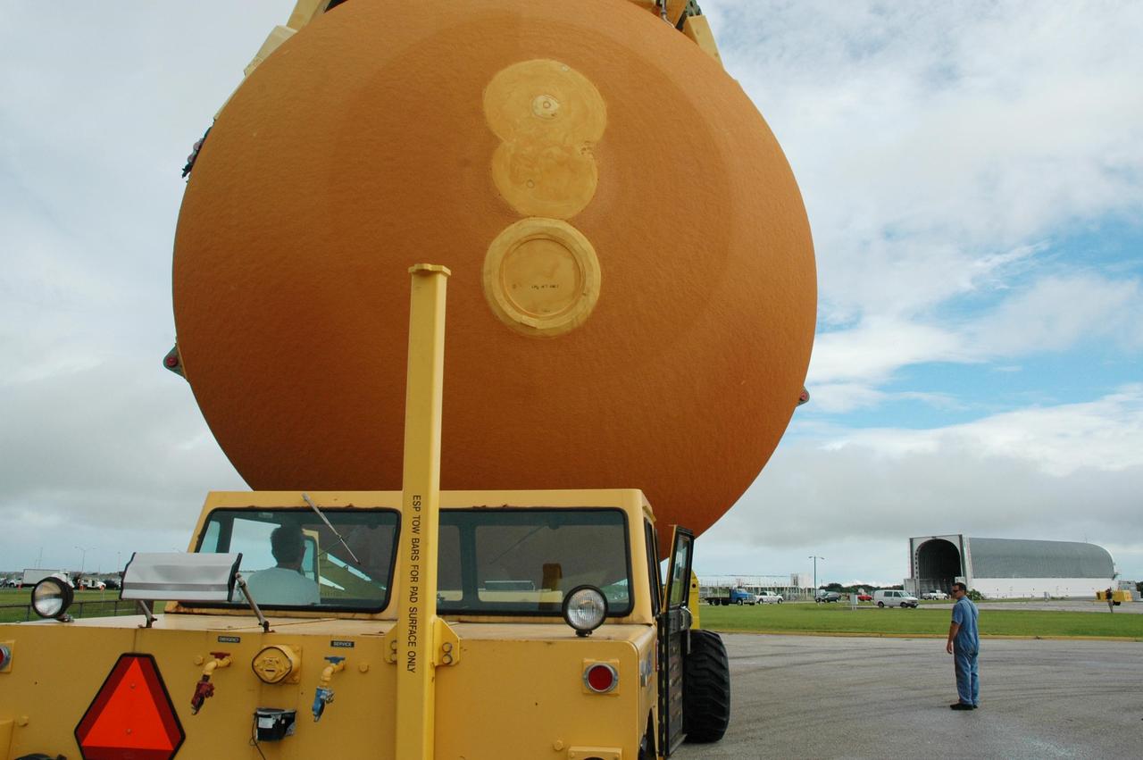 KENNEDY SPACE CENTER, FLA. - The driver of the external tank transporter maneuvers external tank #120 toward the nearby Turn Basin on NASA’s Kennedy Space Center where the barge Pegasus is waiting (right). The barge will be towed to NASA’s Michoud Assembly Facility in Louisiana for additional modifications. This tank is the first of the newly designed tanks that were delivered to Kennedy. Previously, the tank was stacked with Discovery and, more recently, Atlantis. The tank has already gone through two tanking cycles during tanking tests but was replaced with tank #121 for Discovery’s return to flight mission STS-114.