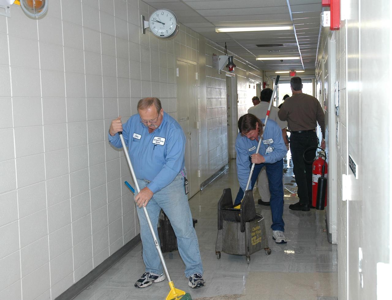 KENNEDY SPACE CENTER, FLA. -   Workers at the NASA Kennedy Space Center mop up water inside a building following the wrath of hurricane Wilma as it crossed the state Oct. 24.   Kennedy’s facilities sustained minor structural damage,  primarily to roofs or from water intrusion. The Vehicle Assembly Building lost some panels on the east and west sides. Some facilities lost power. A total of 13.6 inches of rain was recorded at the Shuttle Landing Facility. The highest wind gust recorded was 94 mph from the north-northwest at Launch Pad 39B, while the maximum sustained wind was 76 mph from the north-northwest at the top of the 492-foot weather tower located north of the Vehicle Assembly Building.