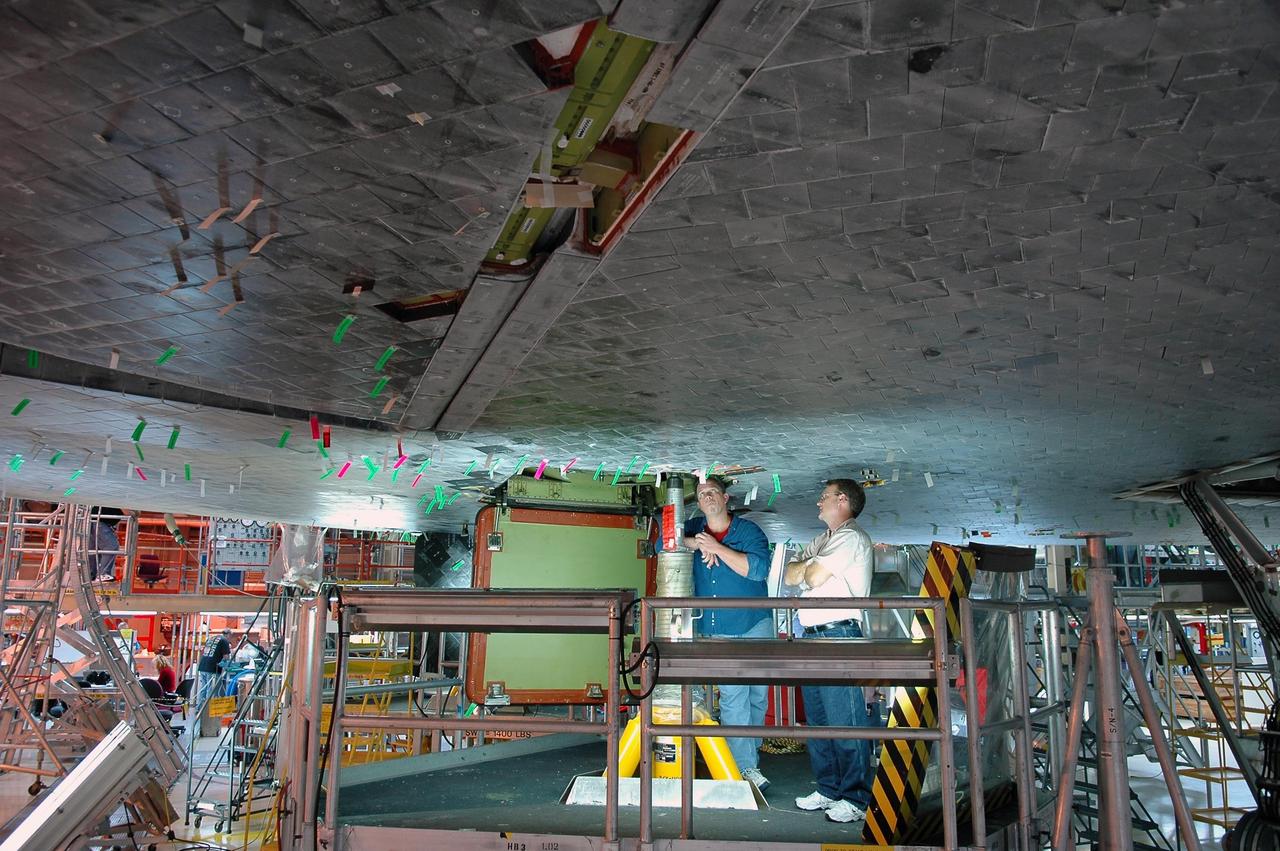 KENNEDY SPACE CENTER, FLA. - In NASA’s Orbiter Processing Facility Bay 3, United Space Alliance technicians are inspecting tile repair on Discovery’s underside. Discovery processing is under way for the second return to flight test mission, STS-121.